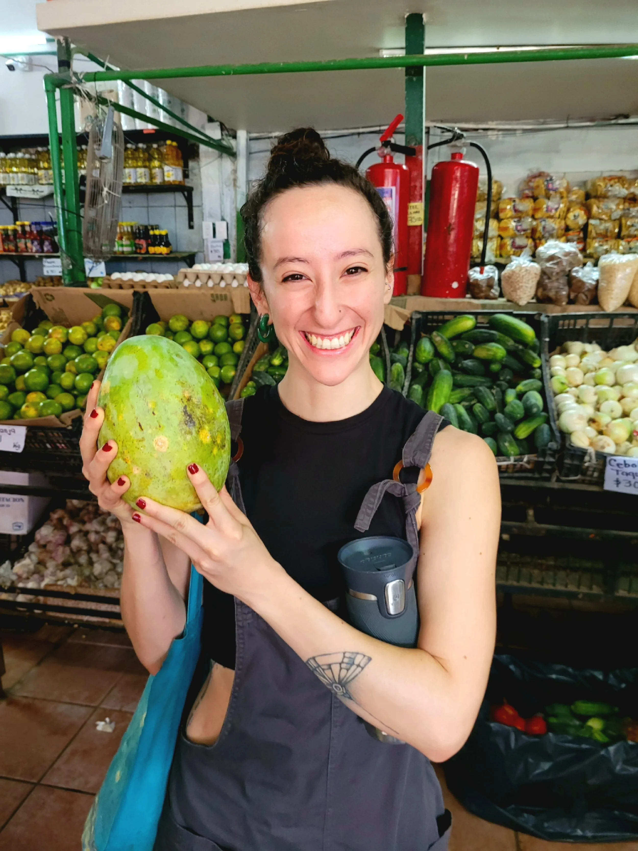 Guest holding papaya at Puerto Vallarta market with My Deztination.