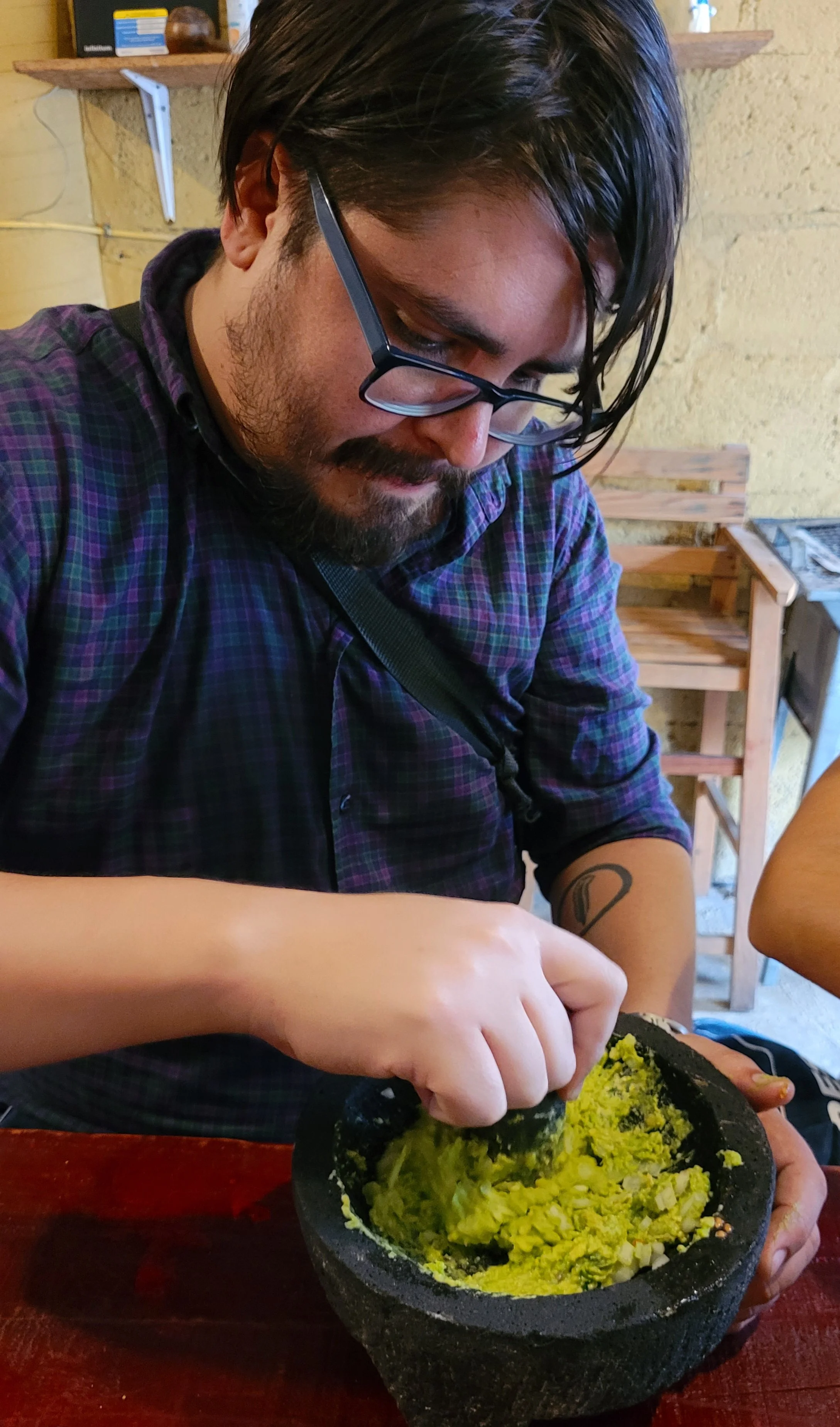 Guest mashing avocado to make guacamole in My Deztination cooking class.