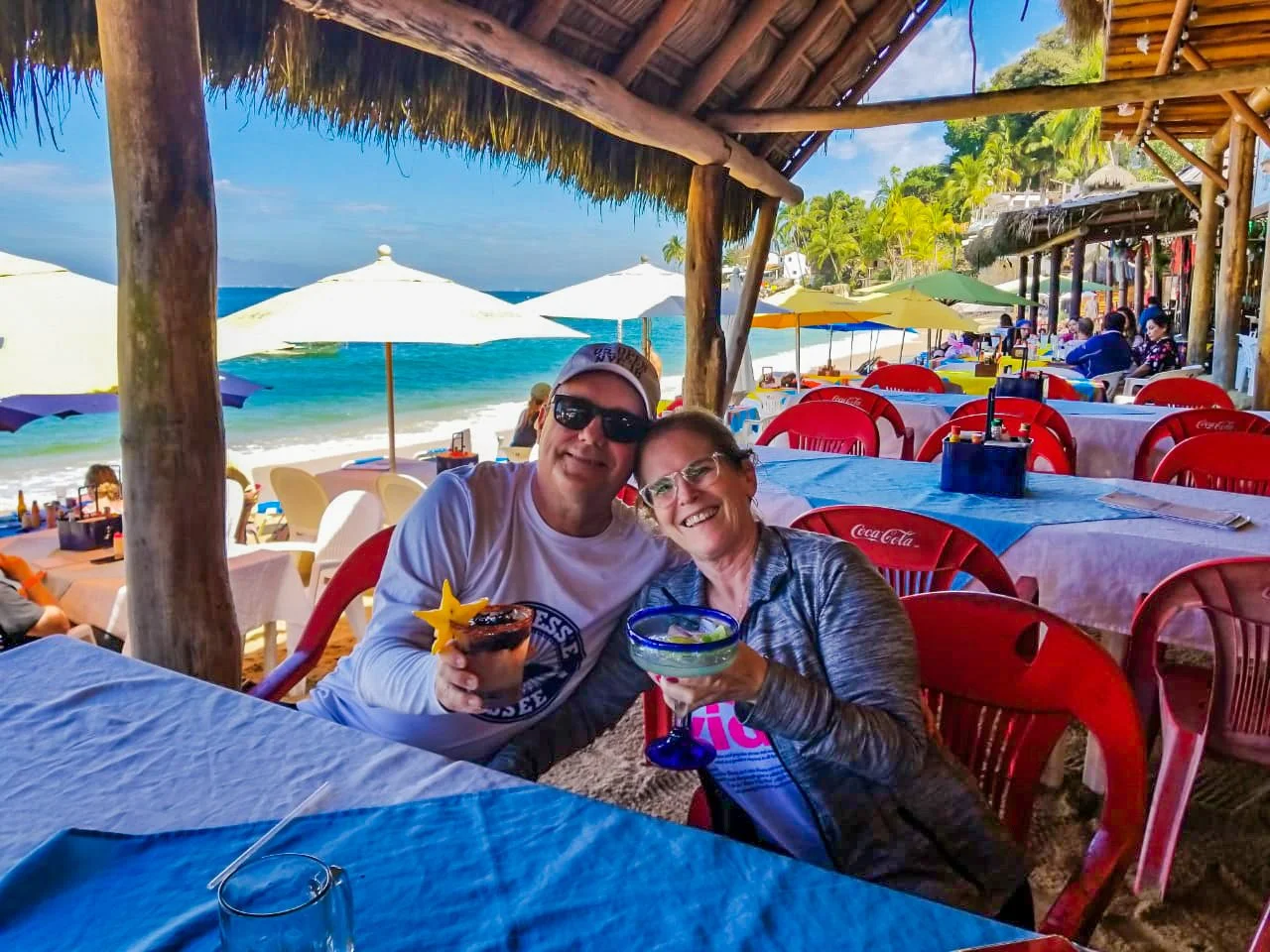 A couple enjoys a fresh seafood lunch at a beachfront restaurant in Las Animas, a perfect stop on My Deztination’s private Los Arcos snorkeling tour.