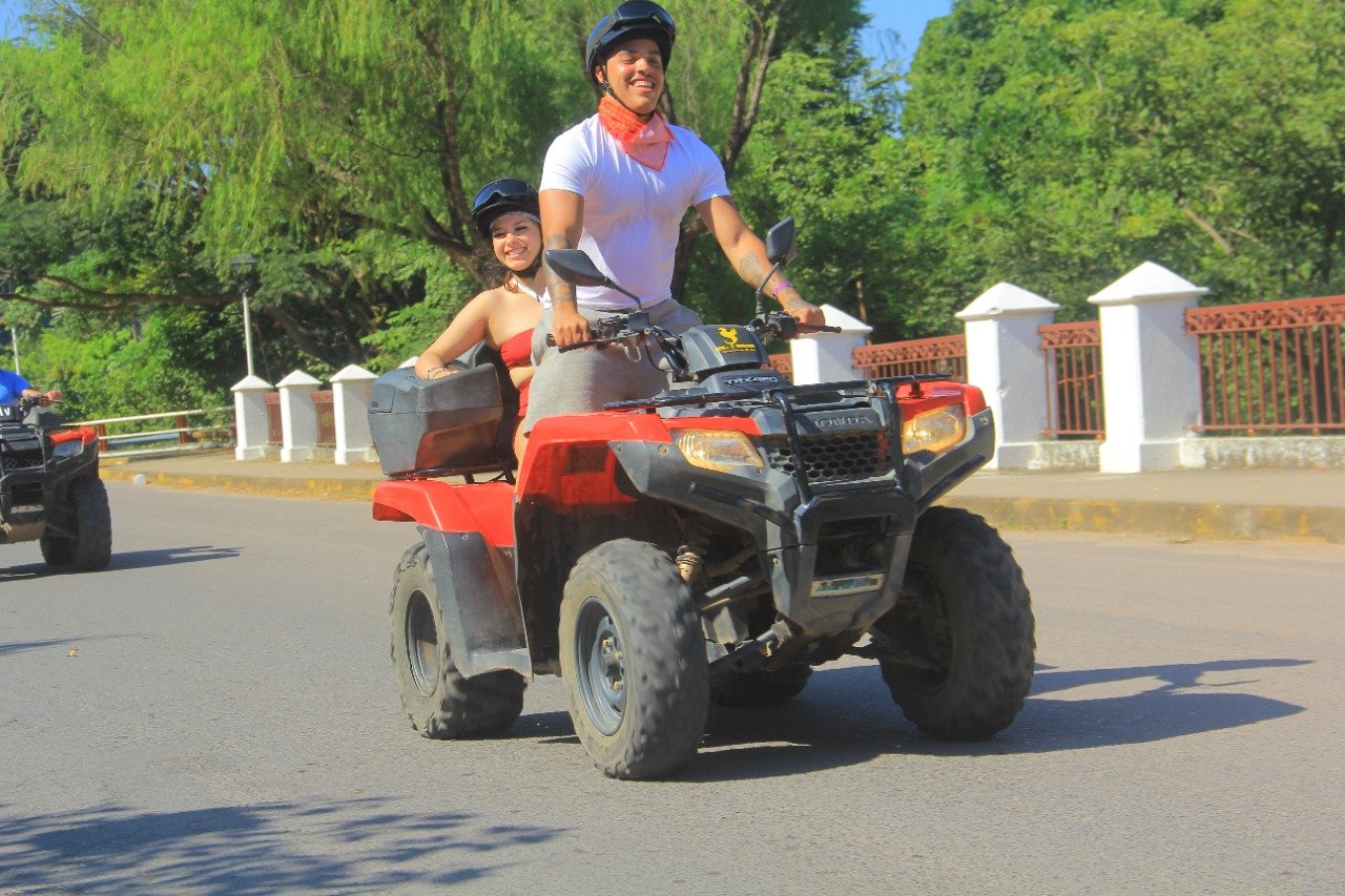 Happy couple driving ATV over bridge on My Deztination city tour.