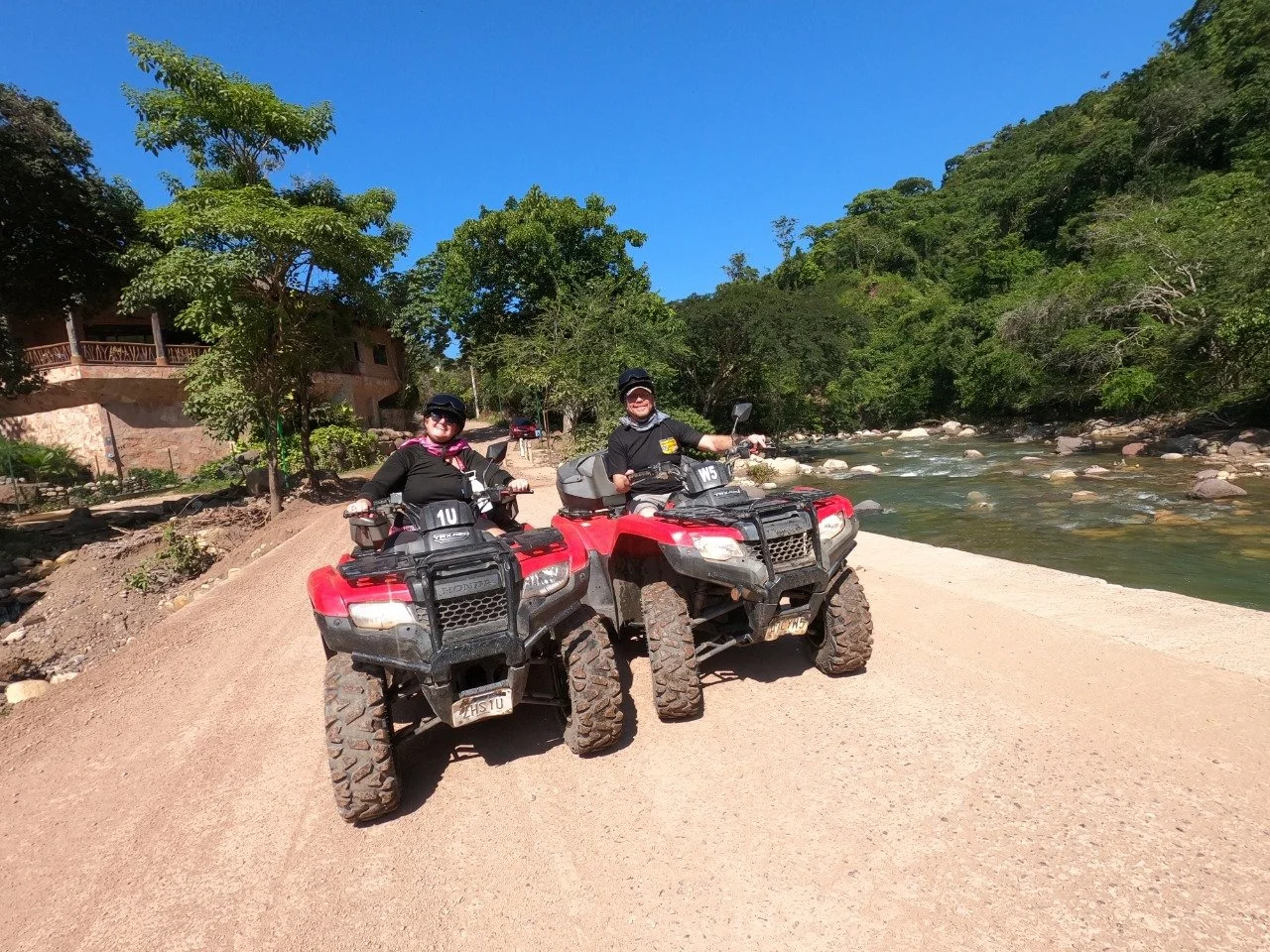 Guests smiling side by side on ATVs with My Deztination.