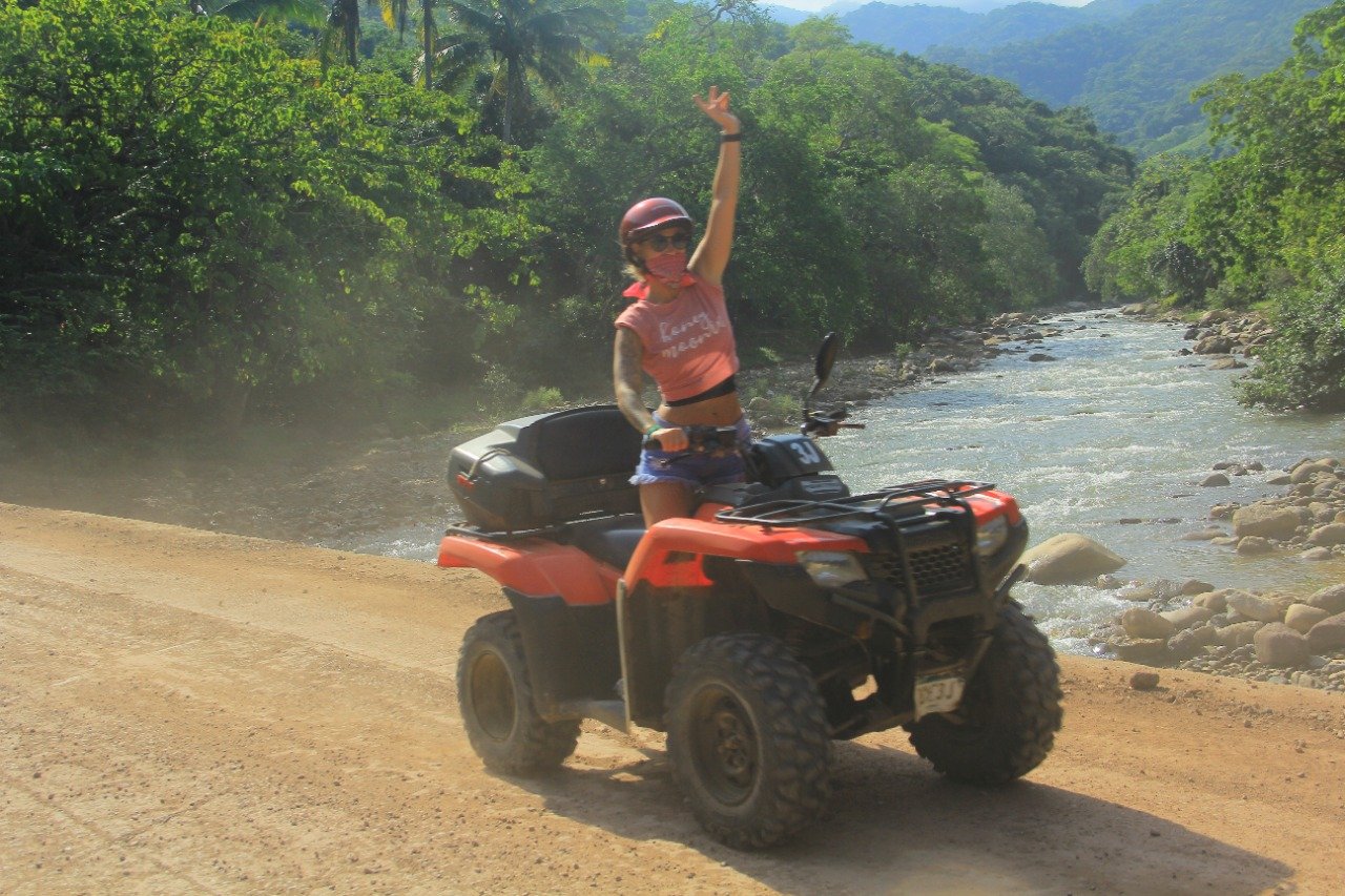 Guest raising hand while crossing bridge on ATV, My Deztination.
