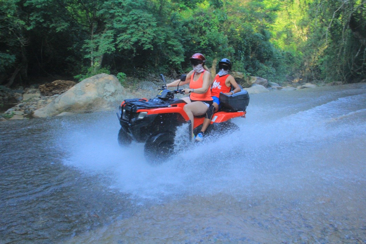 Couple crossing river on ATV with My Deztination.