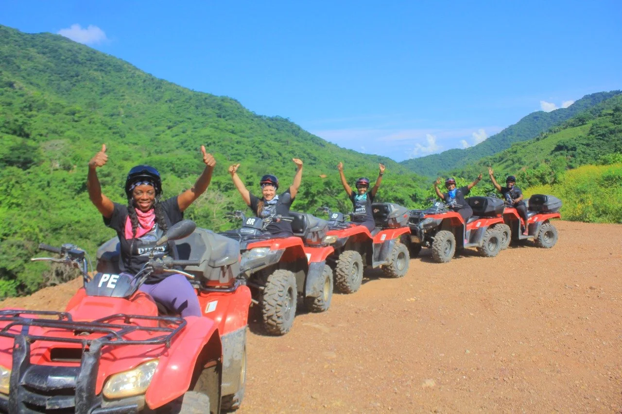 Group of five on ATVs hands up smiling with My Deztination guides.