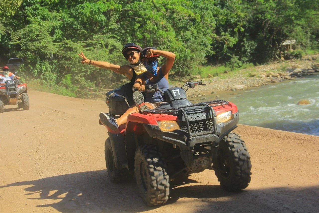 Couple on ATV, passenger posing playfully, My Deztination tour.