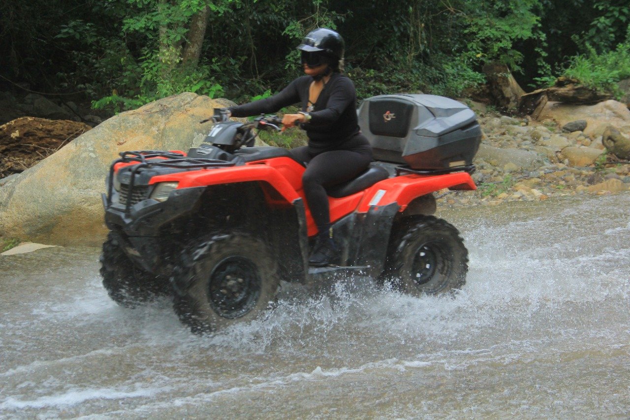 Guest splashing water while riding ATV on My Deztination adventure.