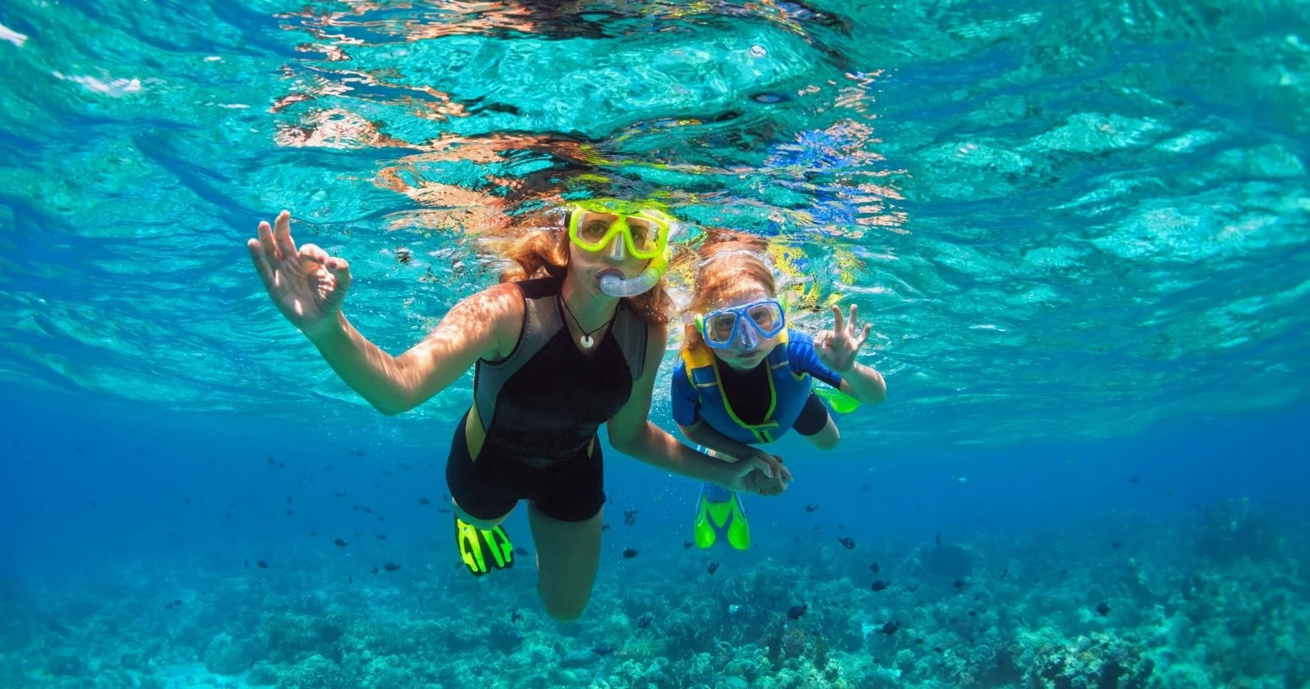 Mother and daughter snorkeling in clear water with My Deztination.