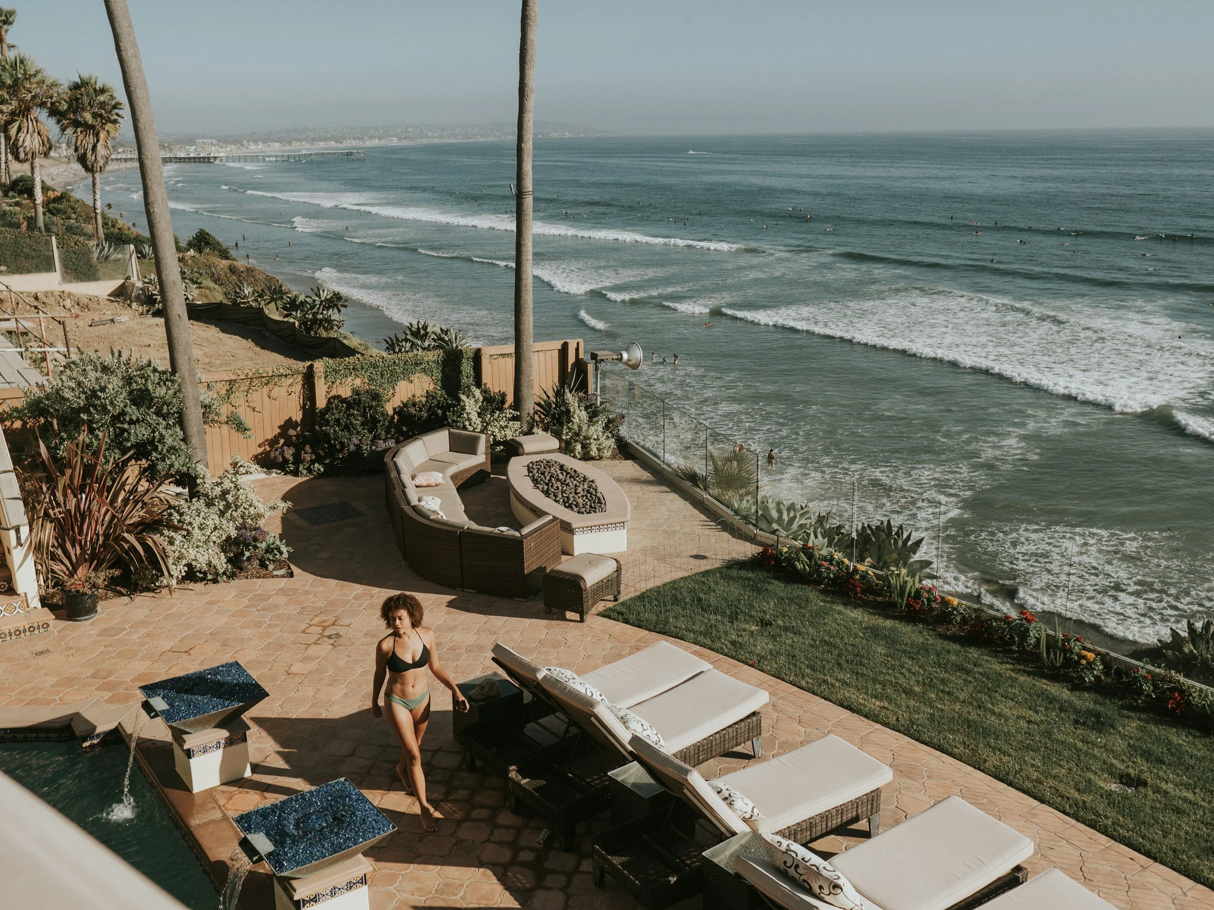 a VIP My Deztination client walking outside along their pool enjoying their new beach home in Mexico