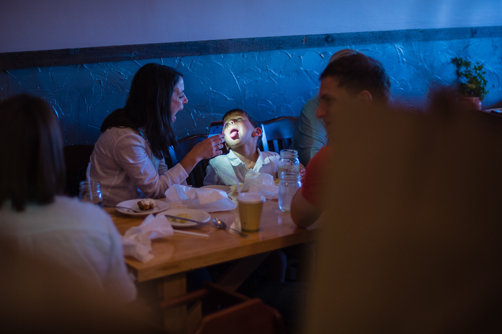 A patron check her son's rapidly growing teeth after enjoying their family meal.