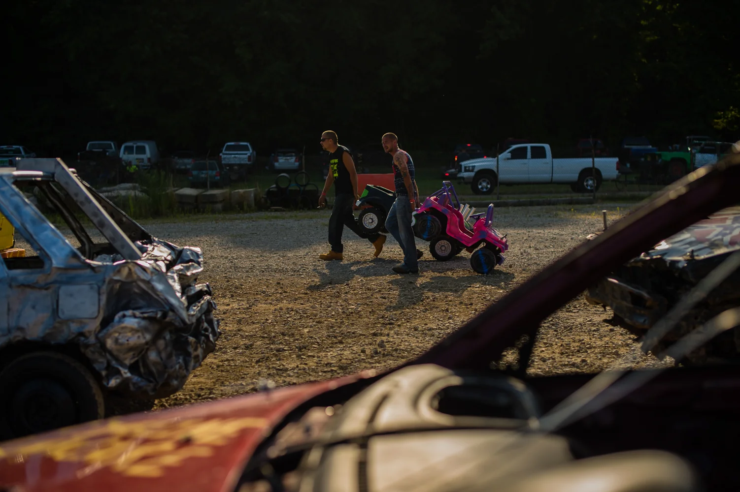 Fathers tow their children's big wheels to the track to prep for the kids' race – a frequently held competition before most demolition derbies.