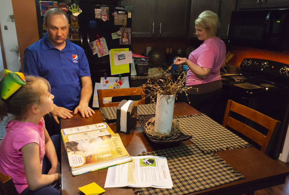 Chaz and Allison, right, Richards help their daughter Braylee, left, with her homework while cooking dinner. Allison and Chaz both work in Athens, but choose to stay in Glouster because of the good people there, and the low cost of living. “If you stay out of the wrong crowd it’s easy living here,” said Chaz Richards.
