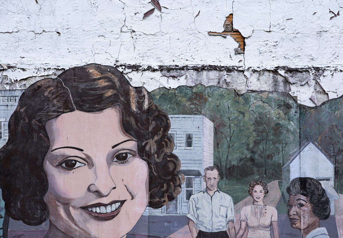 Mural of Glouster that overlooks where the old hotel used to be. A mural is attached to the side of the former Gene Rushing’s Tire Shop. Mayor Miles Wolf says each of the persons portrayed is “someone who did something great in town.” On the left is a portrait of Ida Mae Stoneburner who founded The Glouster Project and restored the Glouster train depot among other things.