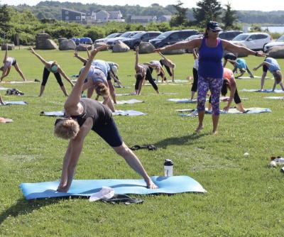 Hathaway leads the outdoor yoga session in 86 degree heat. Photo by: Kenneth Borges.