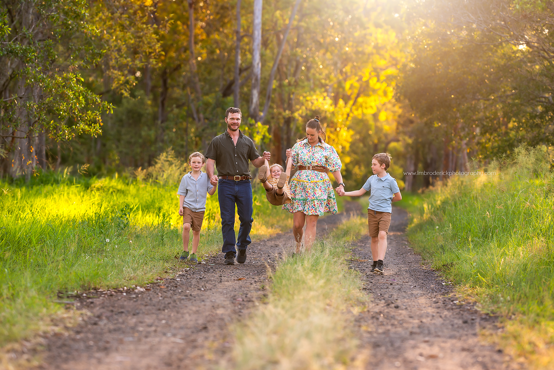 Family of 5 mother and father with their three young boys walking and playing along the Fernvale Rail Trail