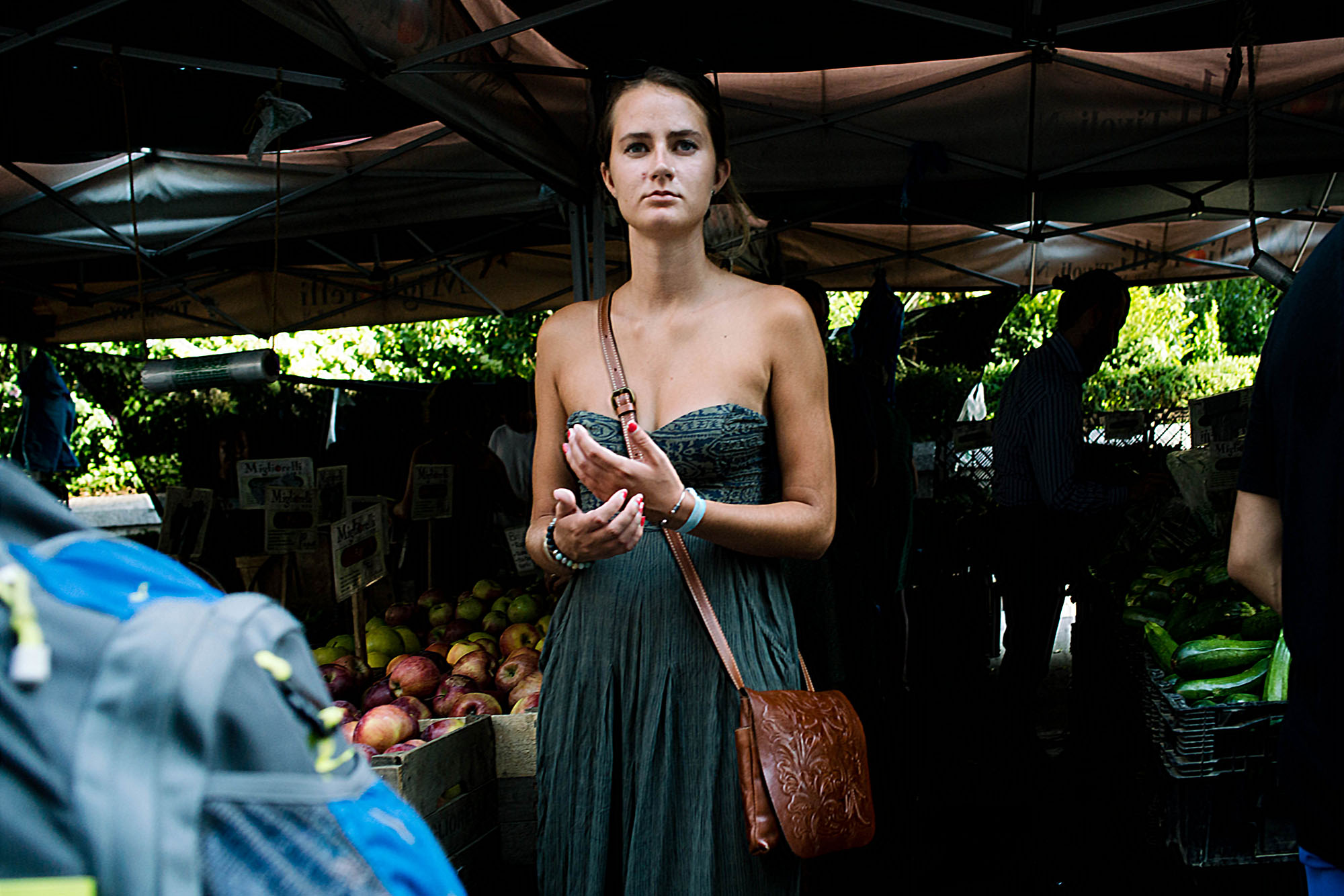 The title image of this post was shot blindly with less than a split second. The subject was looking straight at me, just as I turned around to face her. It was for me a perfect image in my head. She was just coming into the light, wearing a green shoulderless maxi dress, with a produce stand, largely in shadow behind her - also very green. I just took the shot, and hoped for the best. In the end, the image was slightly out of focus, and very distorted, given the short focusing distance from the 28mm lens. I had to do a noticeable amount of vertical and horizontal transformation in Lightroom, in addition to a rotational correction. The focus was improved with the camera shake reduction filter in Photoshop. The image was exported large from Lightroom, and downsized in Photoshop. After all that work in post, this image became usable.