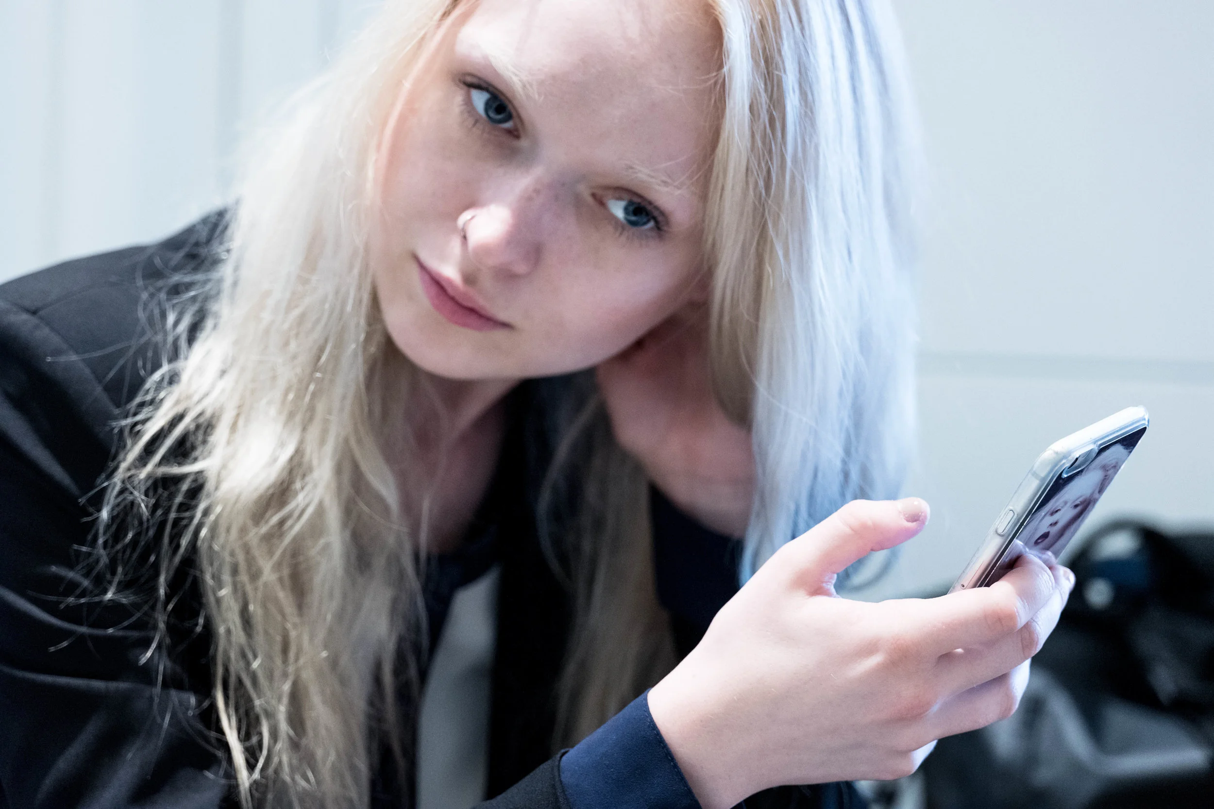 Focusing on her iPhone.