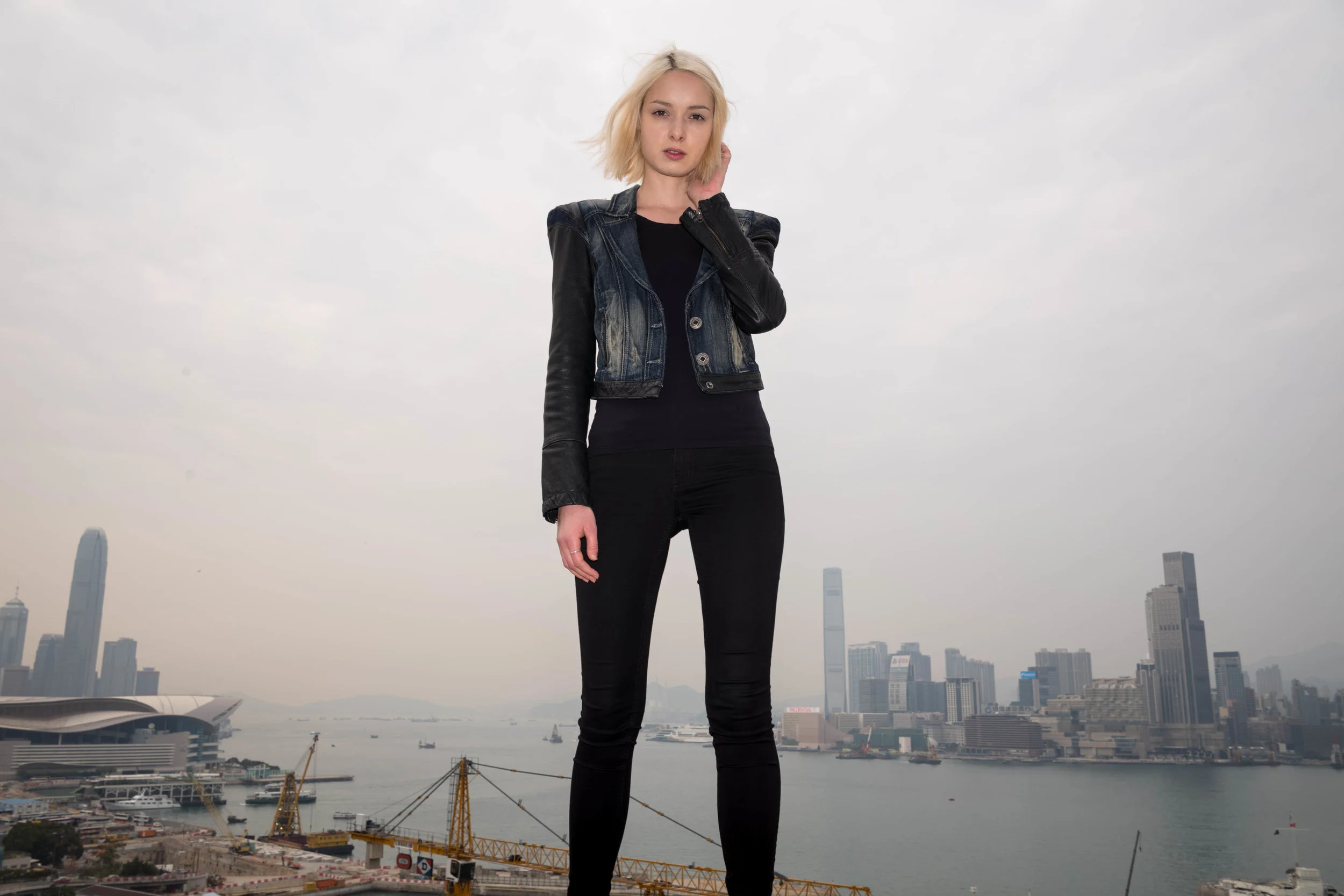On the edge with Hong Kong harbor behind her.