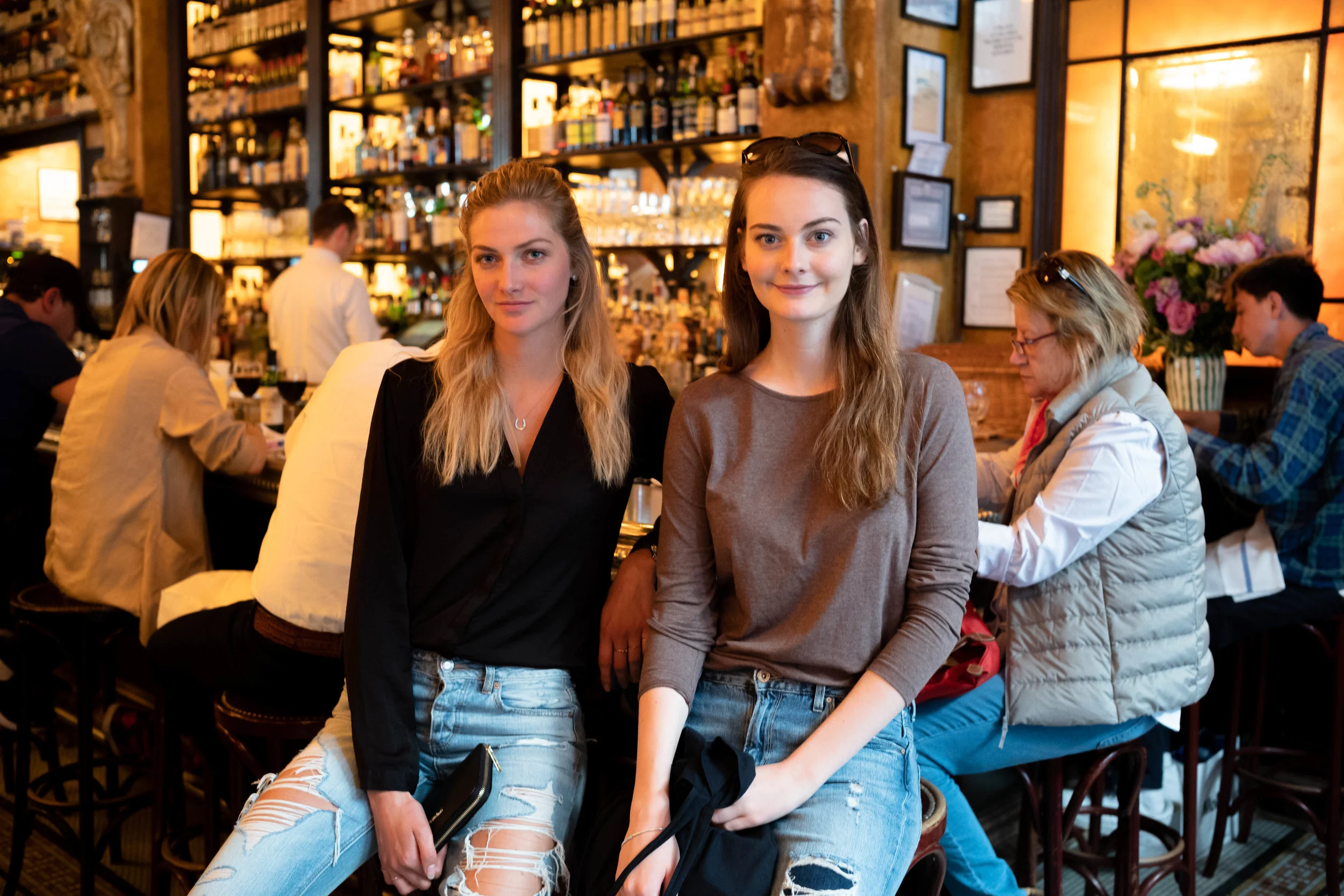 Leica M10 + 35mm f/1.4 Summilux AA - An easy photo of Lydia and Anna seated by the bar. The people in the background are not obtrusive, since they are evenly distributed while providing environmental context.