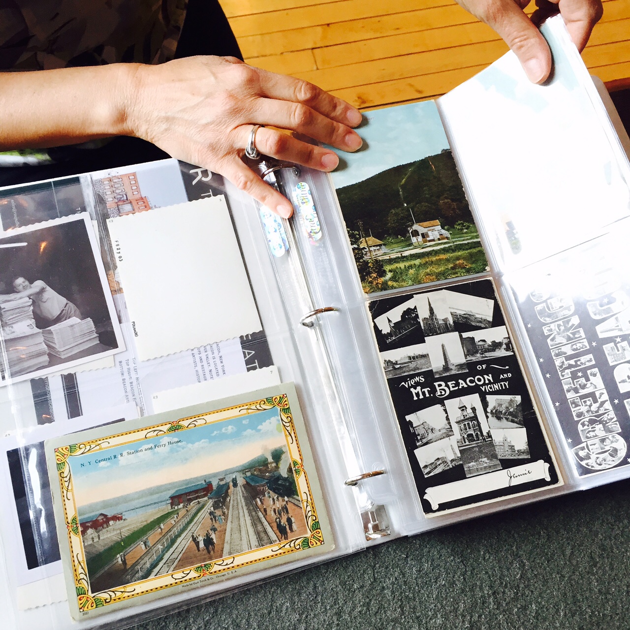 Diane Lapis, Trustee of the Beacon Historical Society, showing their collection of postcards, which serve as inspiration for a new column at A Little Beacon Blog.