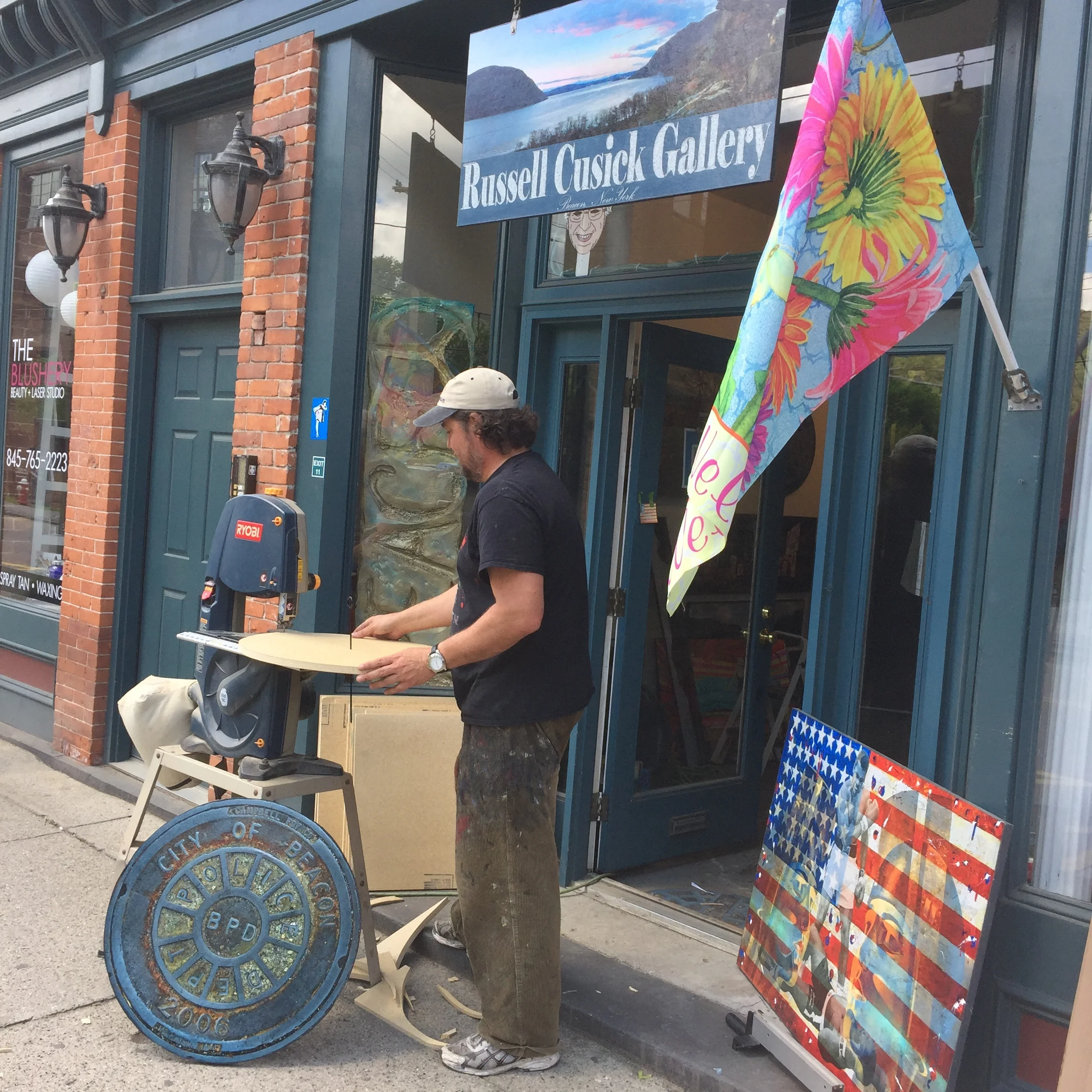 The artist Russell Cusick outside of his East End gallery, making one of his signature Beacon manhole covers.