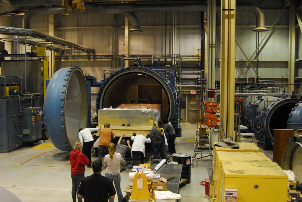 Everyone helps push the mold into the Autoclave for curing.