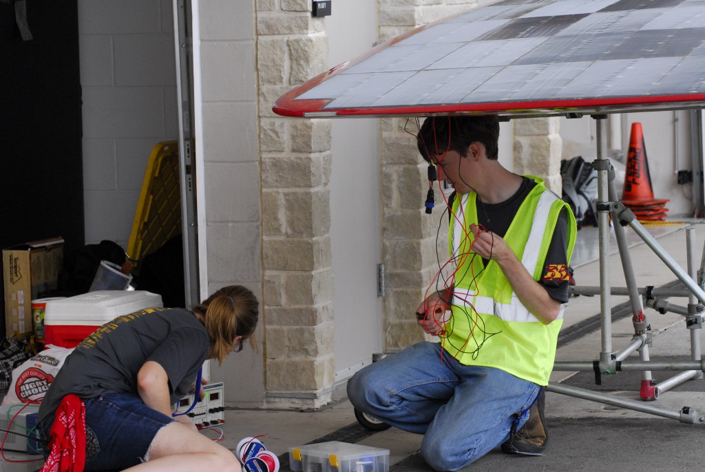 Team Members Arlo Siemsen and Stephanie Wilson work on some electrical wiring for the solar array power trackers.