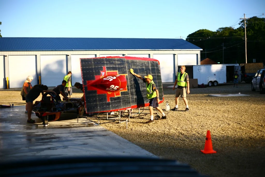 Team member Alex Nelson wipes down the solar array before our morning charge in Waverly, IA.