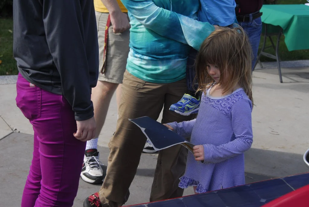 A young visitor checks out a sample of the solar cells that cover the surface of Centaurus III.