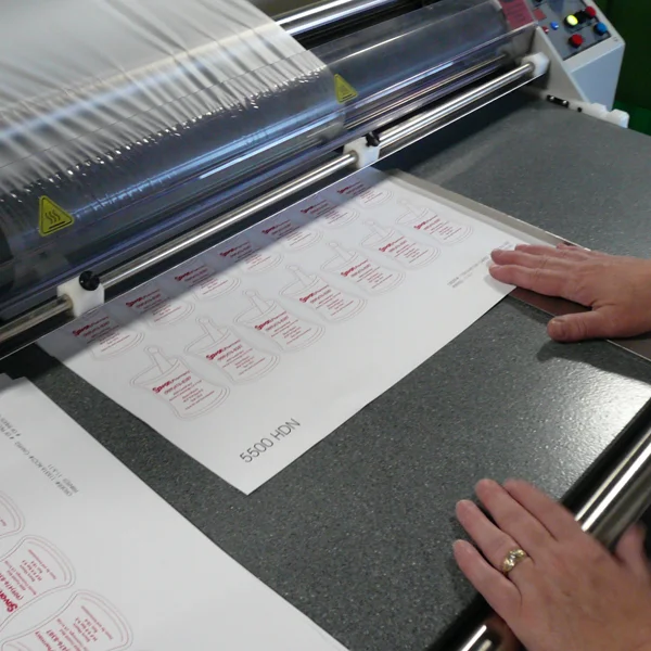 close up of woman laminating custom printed motar and pestle magnets