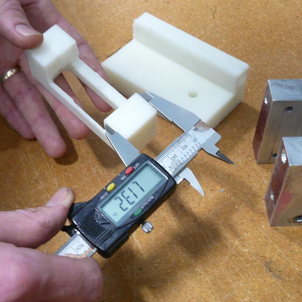 close up of a person measuring a housing unit for a custom engineering project
