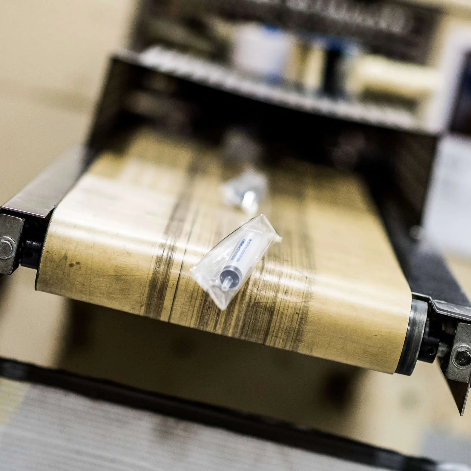 packaged syringes coming off of conveyor belt