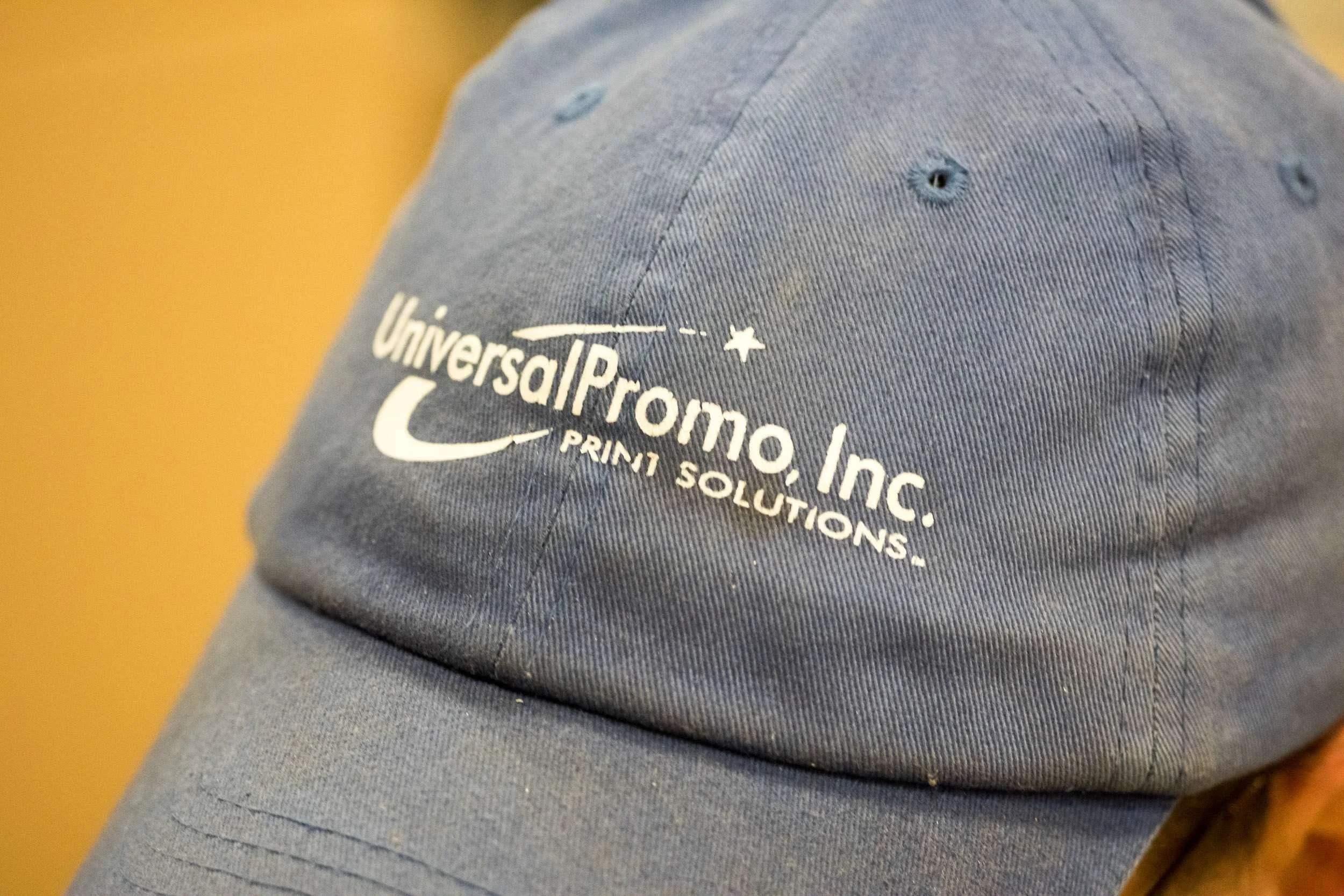 blue hat with universalpromo company logo heat transferred on front