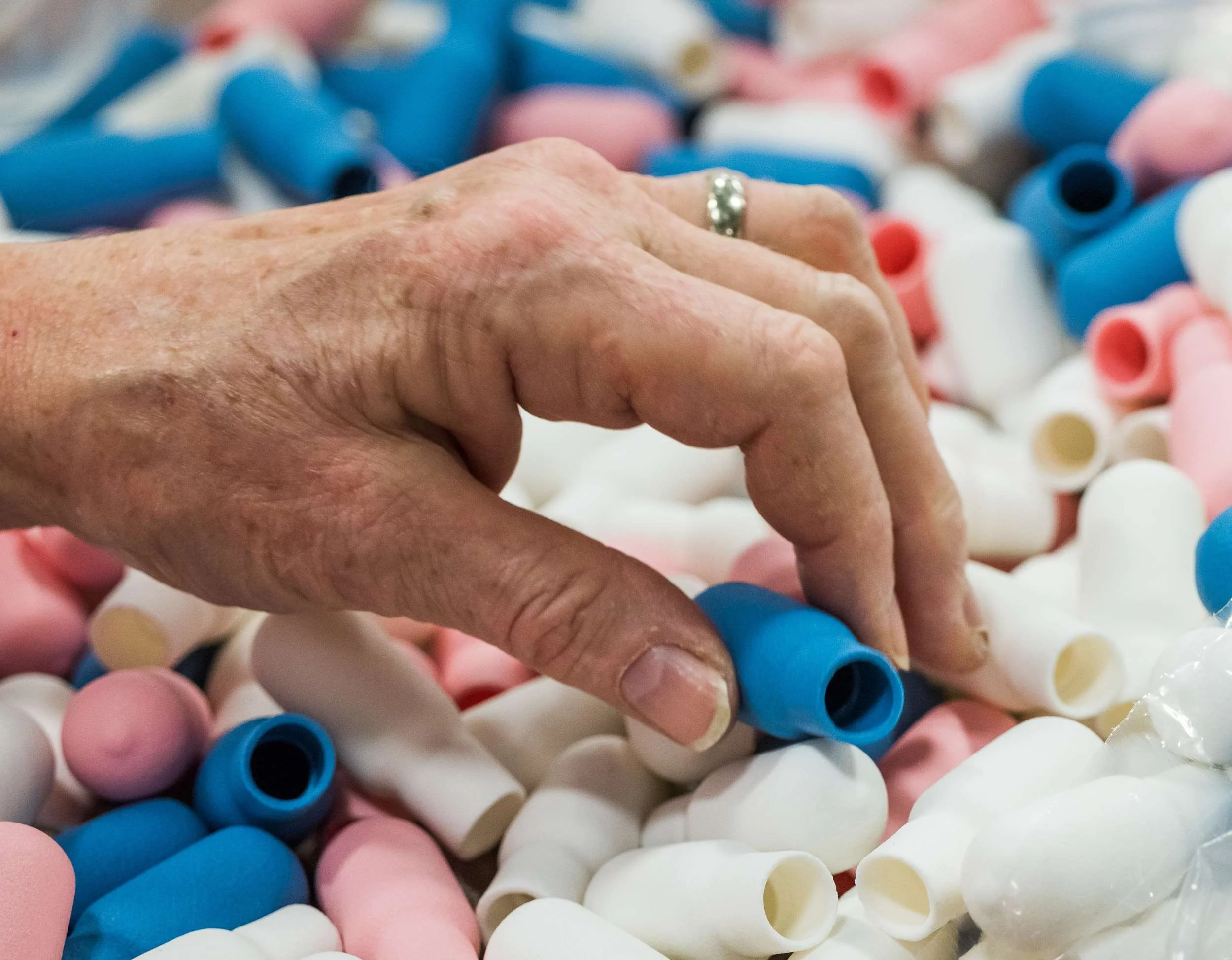 close up of a person picking up dropper bulbs for assembly