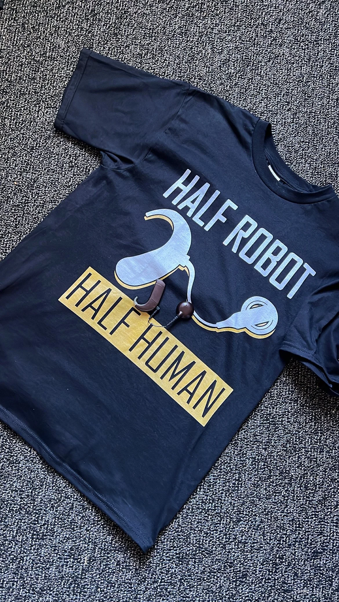 A shirt saying "Half robot, half human" with processor laying on top of the shirt.