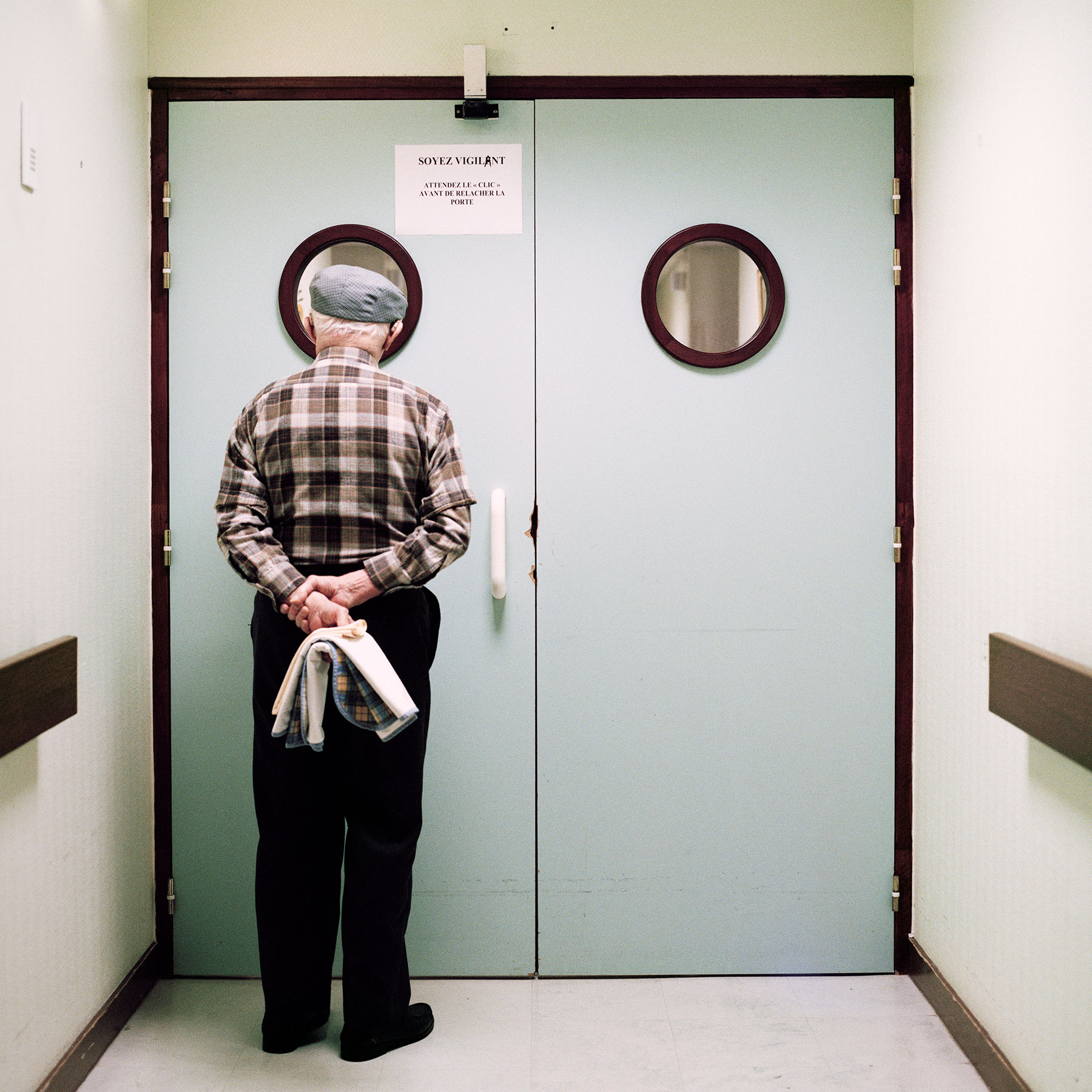  Resident stands in front of the ward’s locked exit. Doors and blocked passing’s are disturbing elements to a person suffering from Alzheimer’s due to the common symptom to regularly often wander about. As a result of the potential risk of getting lo