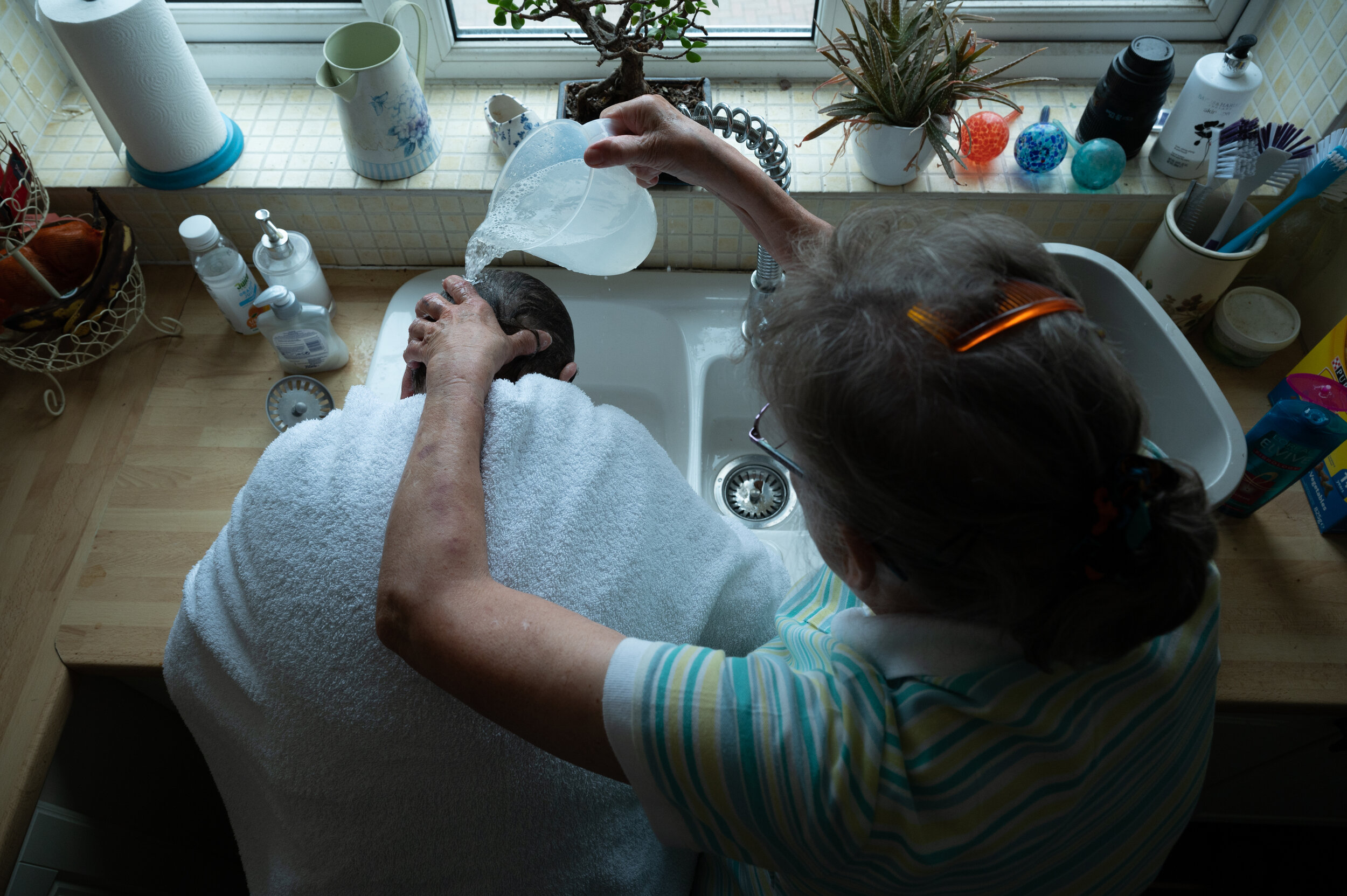  A friend washes mum's hair. After being diagnosed with dementia, friends were few and far between. Mum became isolated as friends and family began to distance themselves. A common occurence people with dementia. 