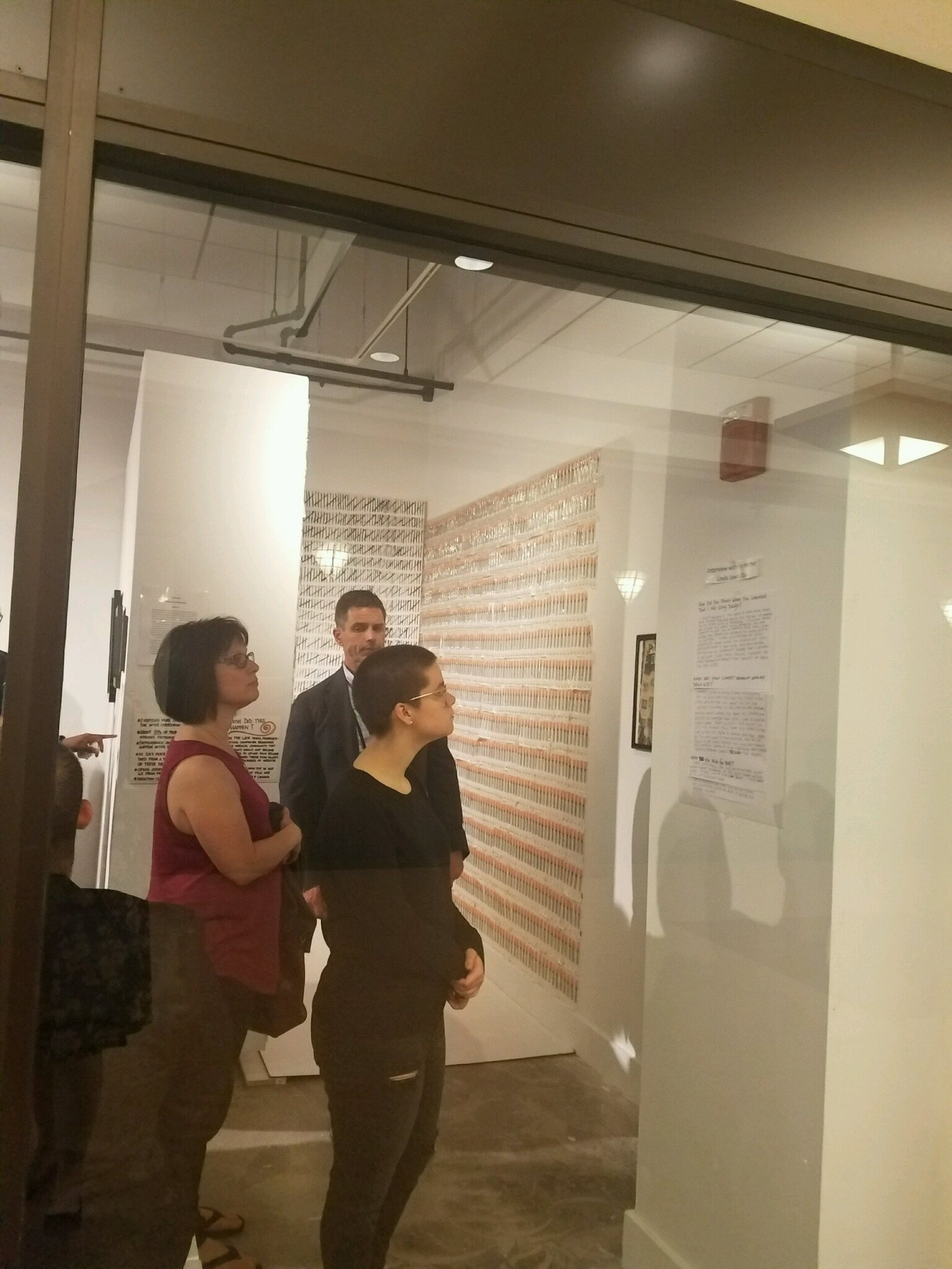 People reading facts about the opiate crisis before entering the installation 