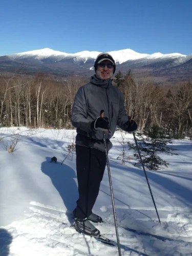 The 62 year old XCSkiResorts.com editor takes a break on the Mountain Road in the shadow of Mt. Washington