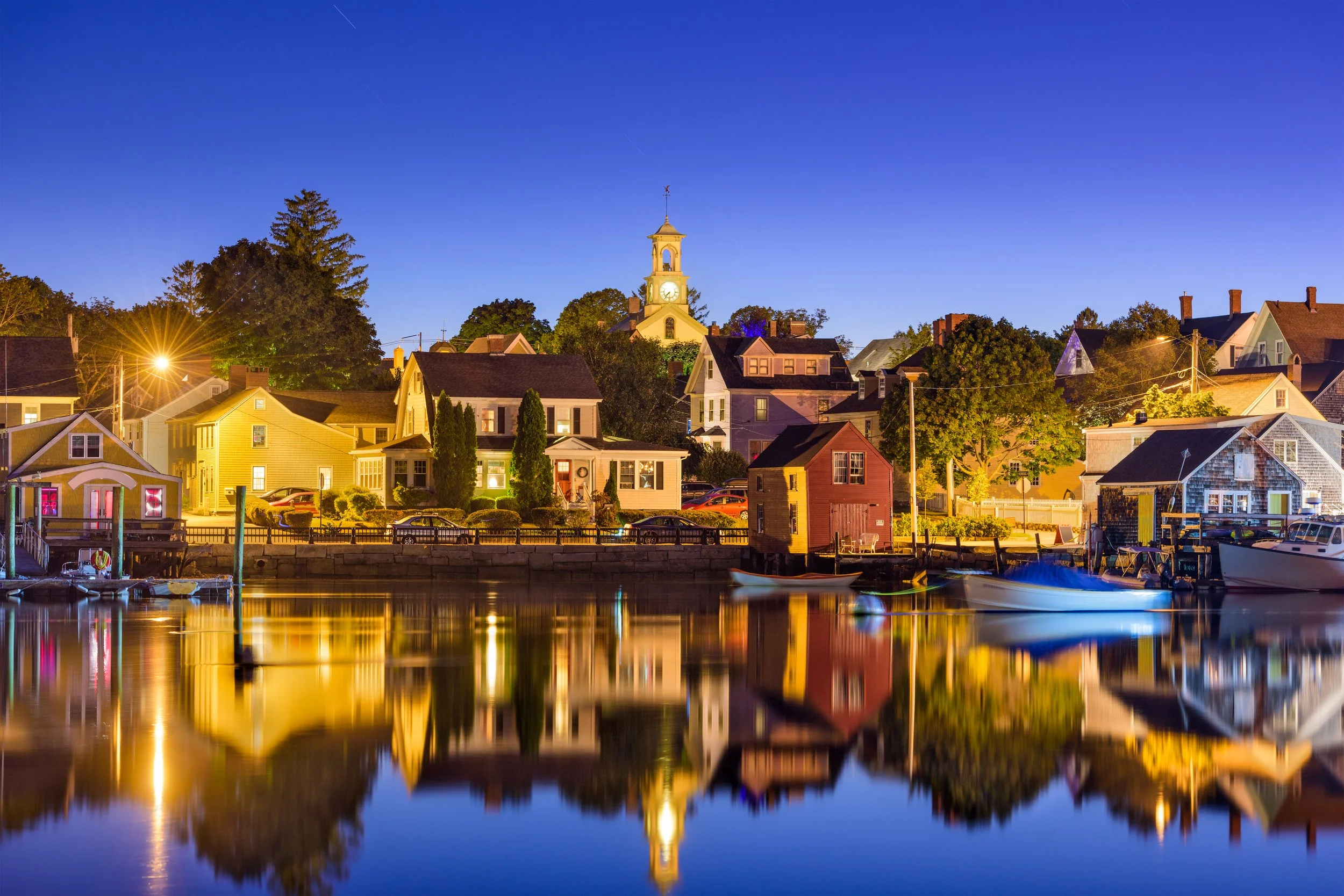 A harbor view at dusk featuring colorful houses along the waterfront, showcasing professional photo and video capabilities at Windwood Productions