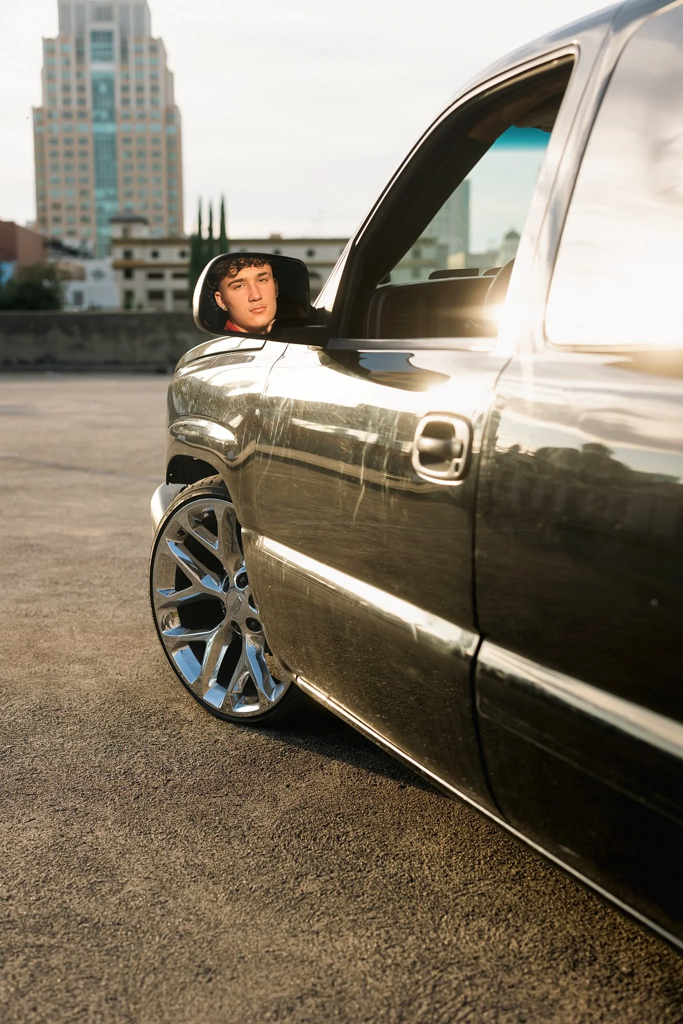 Woodcreek High School senior guy photographed with his truck on a rooftop in Downtown Sacramento during his senior portrait session.