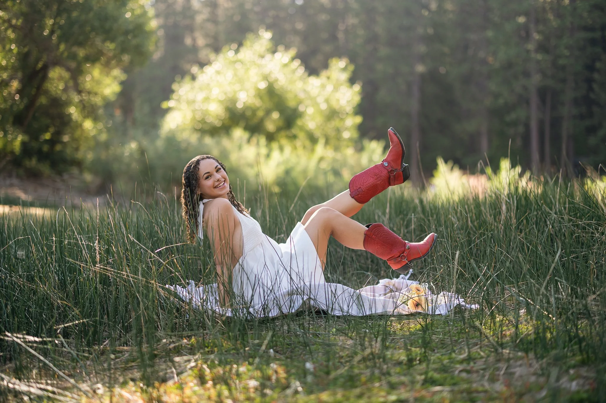 Vista del Lago High School senior wearing red cowboy boots during her senior pictures at Sly Park near Folsom, California.
