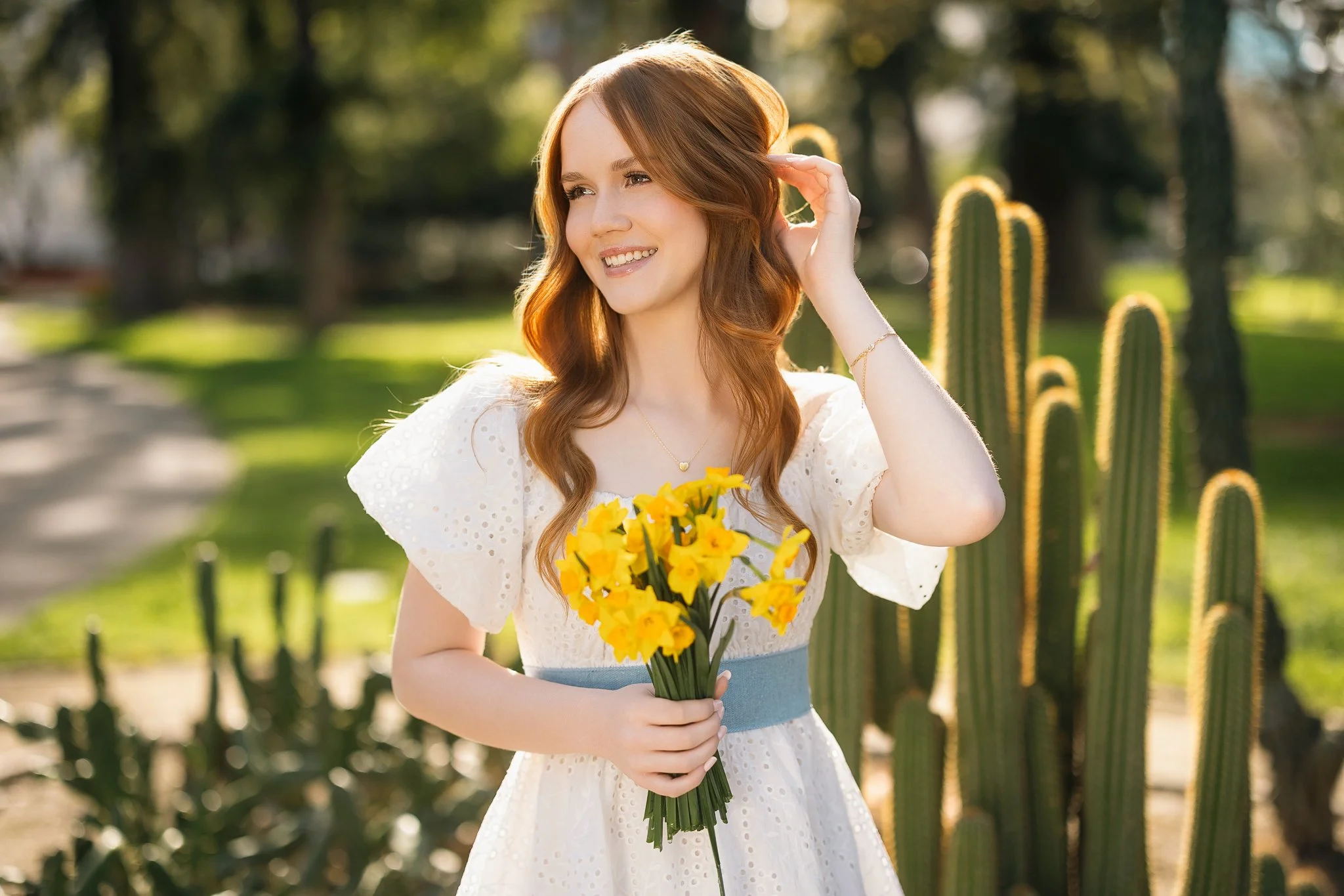 senior pictures of a girl in a white dress at the capital garden in Sacramento