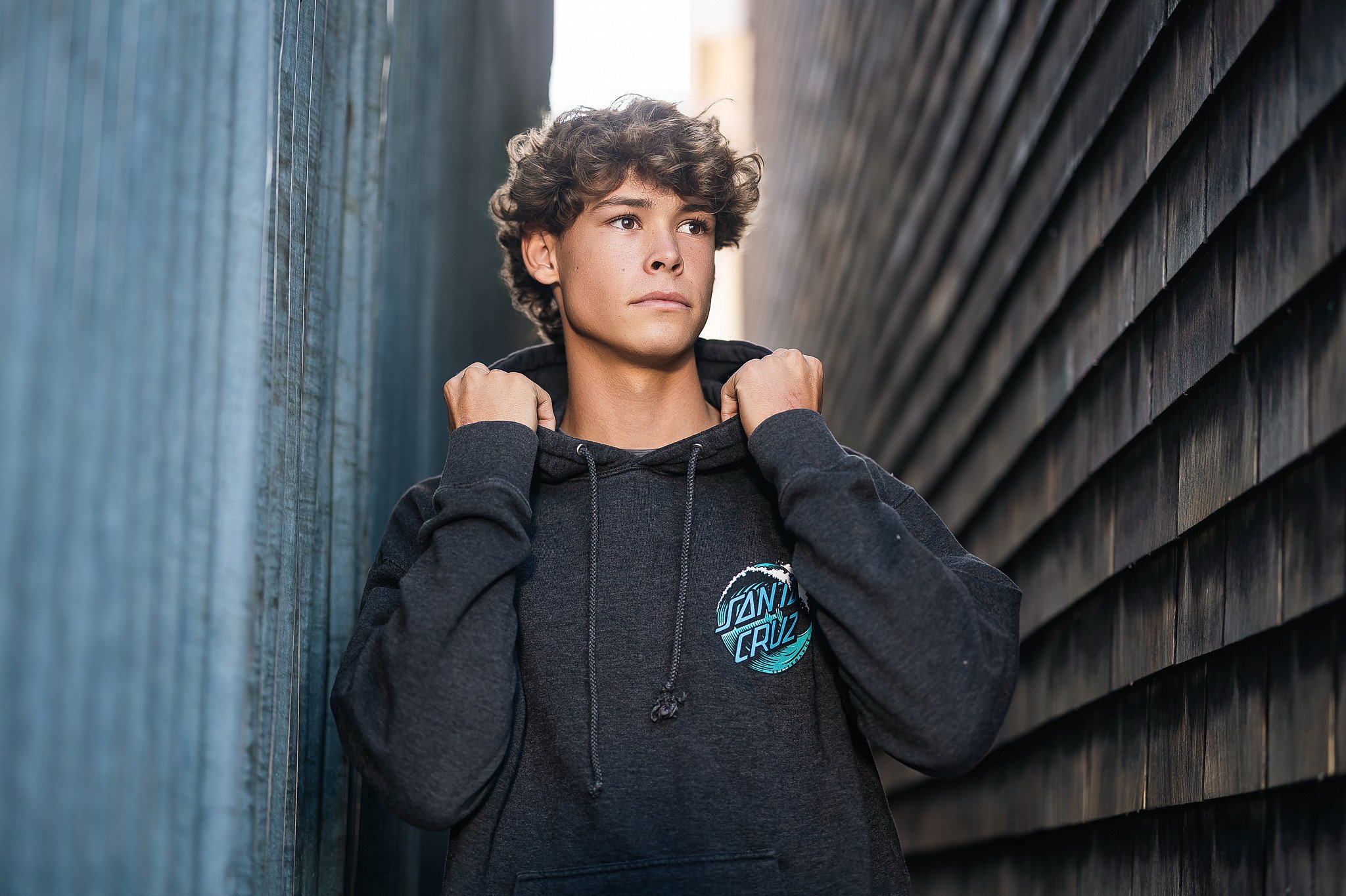 Elk Grove High School senior guy posing in a hoodie during his senior pictures in historic Old Town Elk Grove, California.