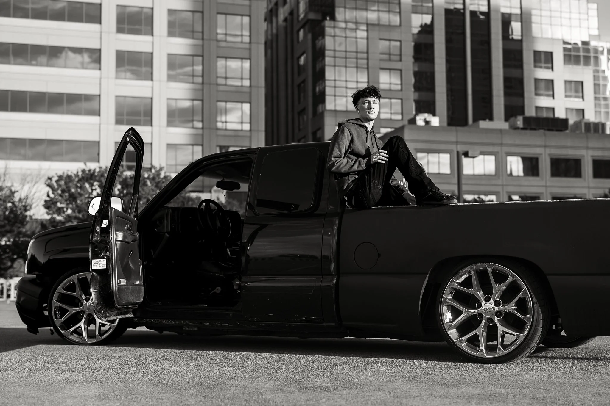 Pleasant Grove High School senior guy posing with his truck during an urban senior portrait session in Downtown Sacramento.