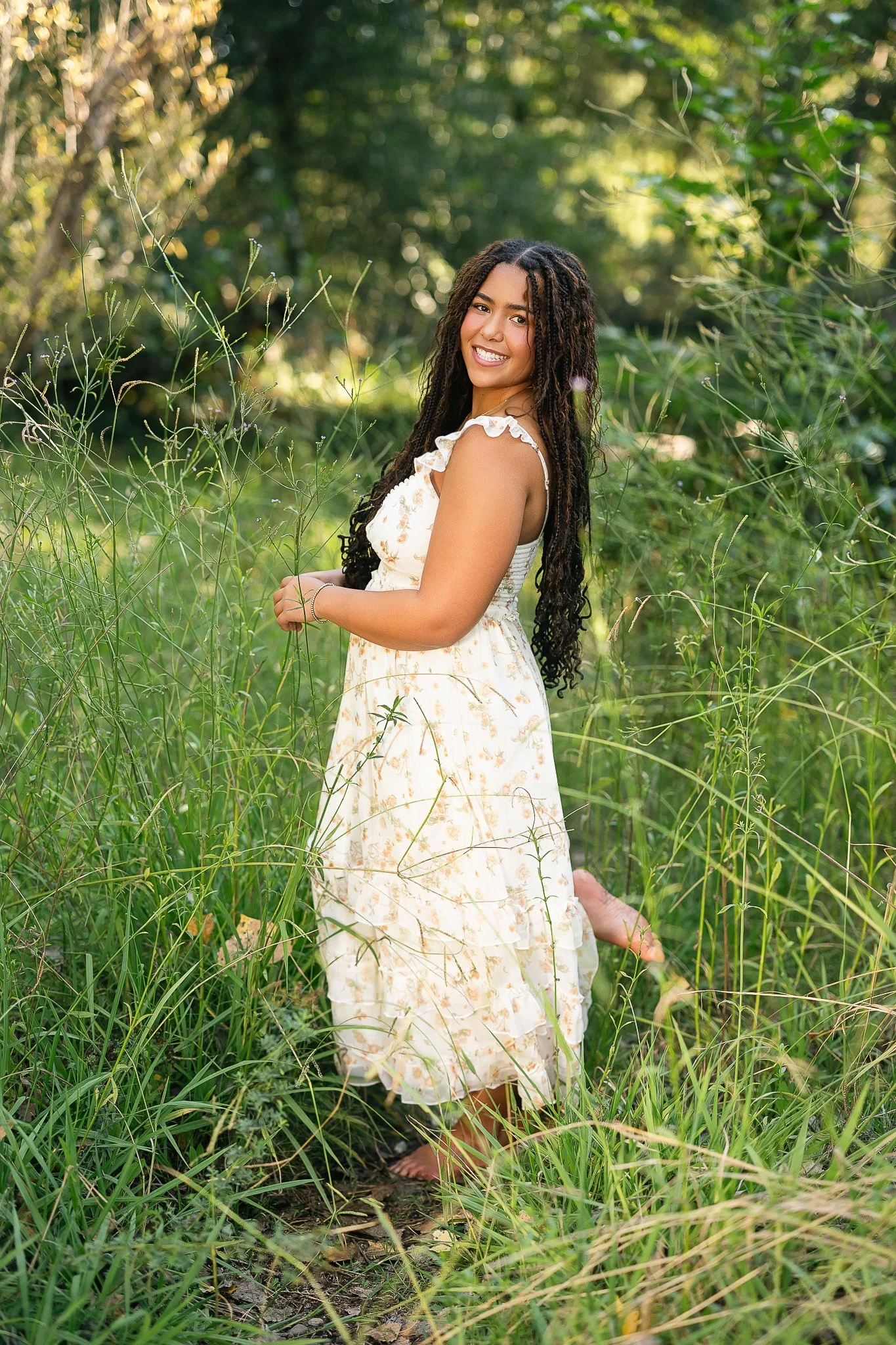 Oak Ridge High School senior posing in a grassy field near Folsom, California during her senior picture session.