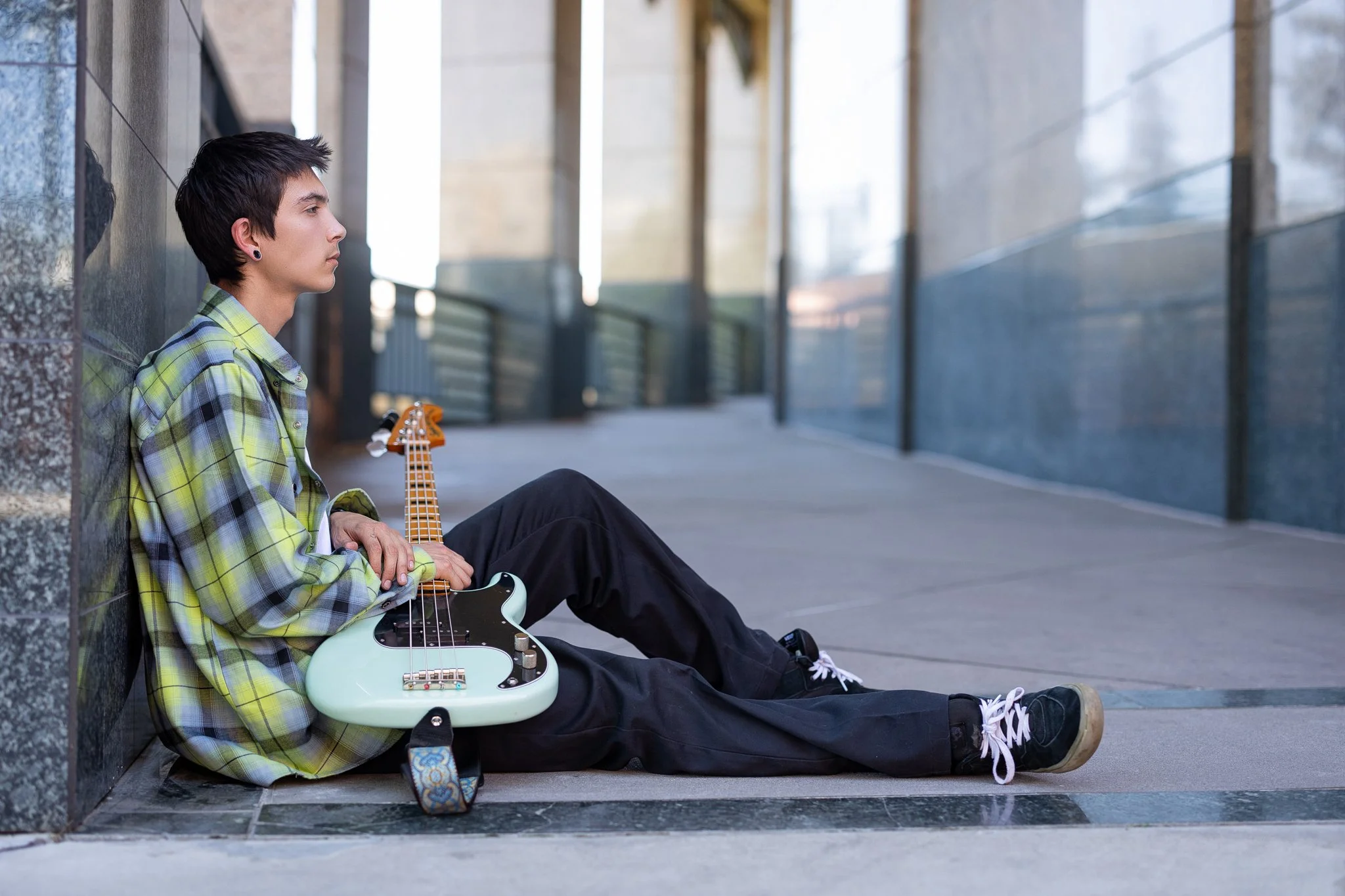 Unique senior picture idea for guys featuring an Inderkum High School senior with his bass guitar during an urban senior portrait session in Downtown Sacramento, California.