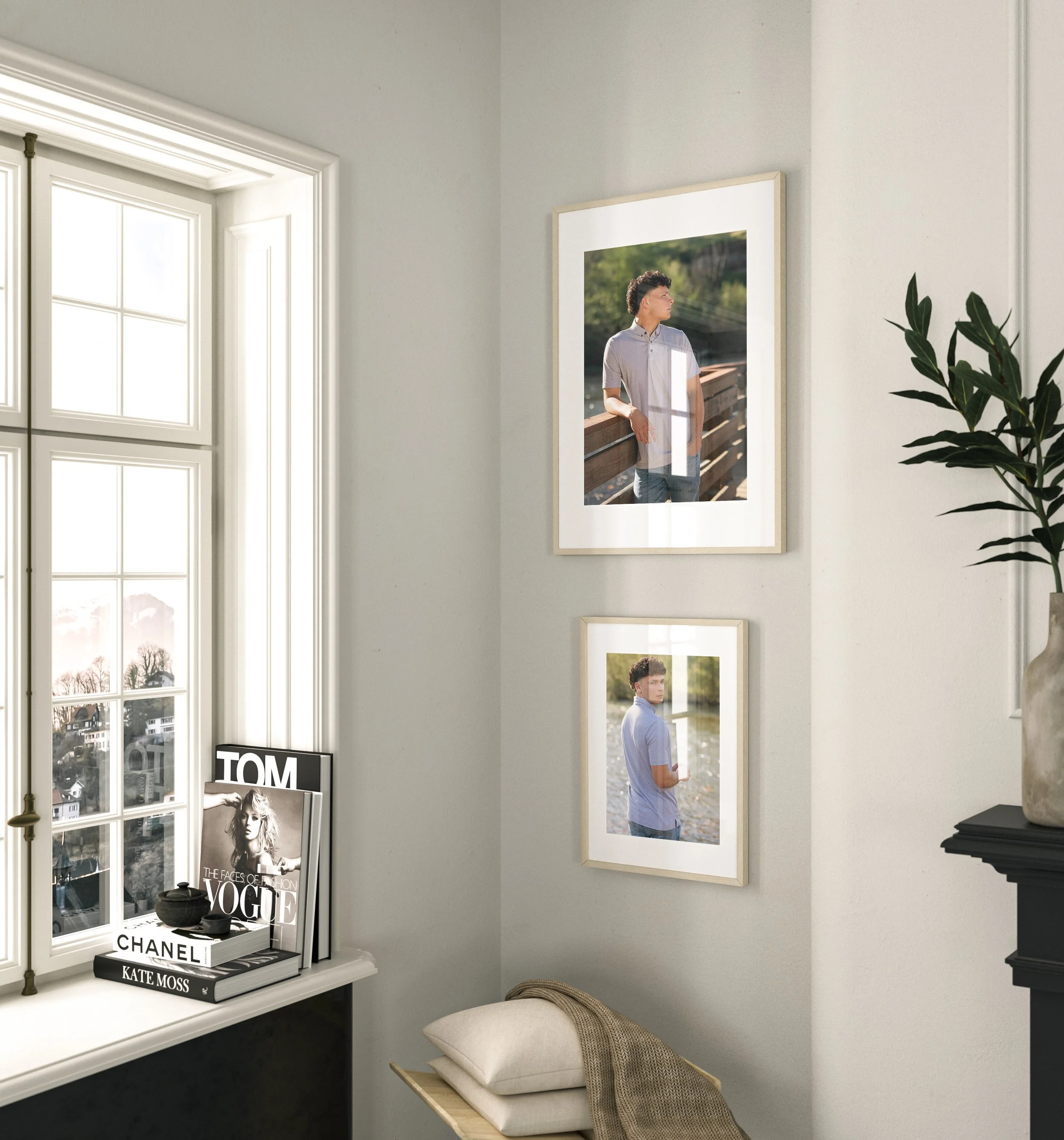 Interior view of a corner in a living space with framed photographs of a young man, decorative magazines, and a small shelf with stacked pillows, overlooking a window showing a snowy landscape outside.