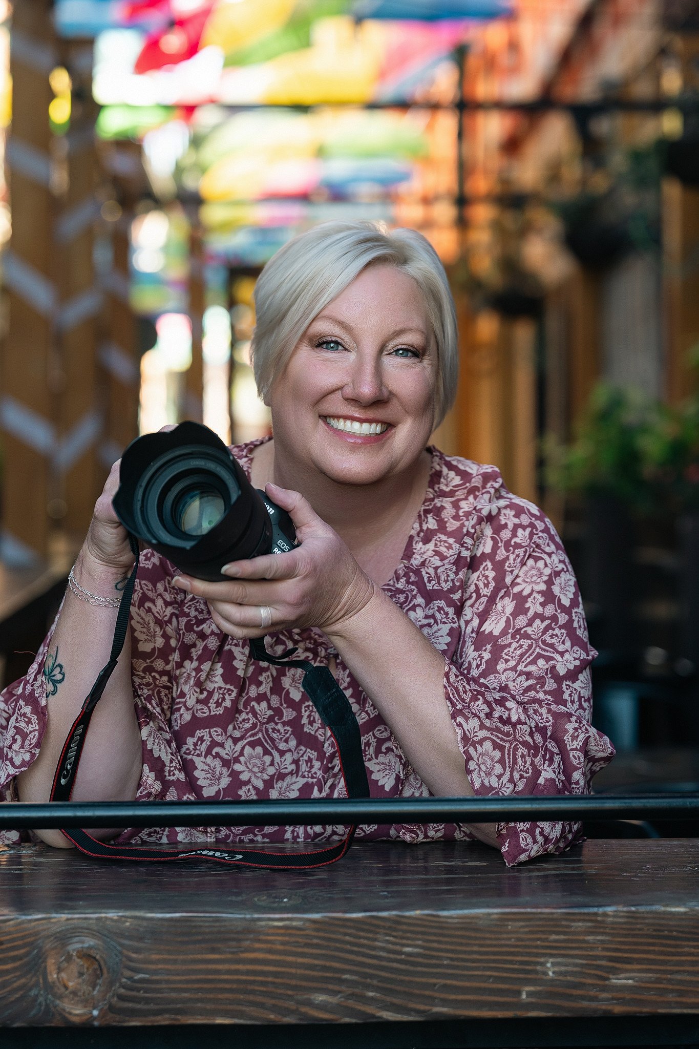 A sacramento, ca high school senior photographer smiling with her camera in hand.