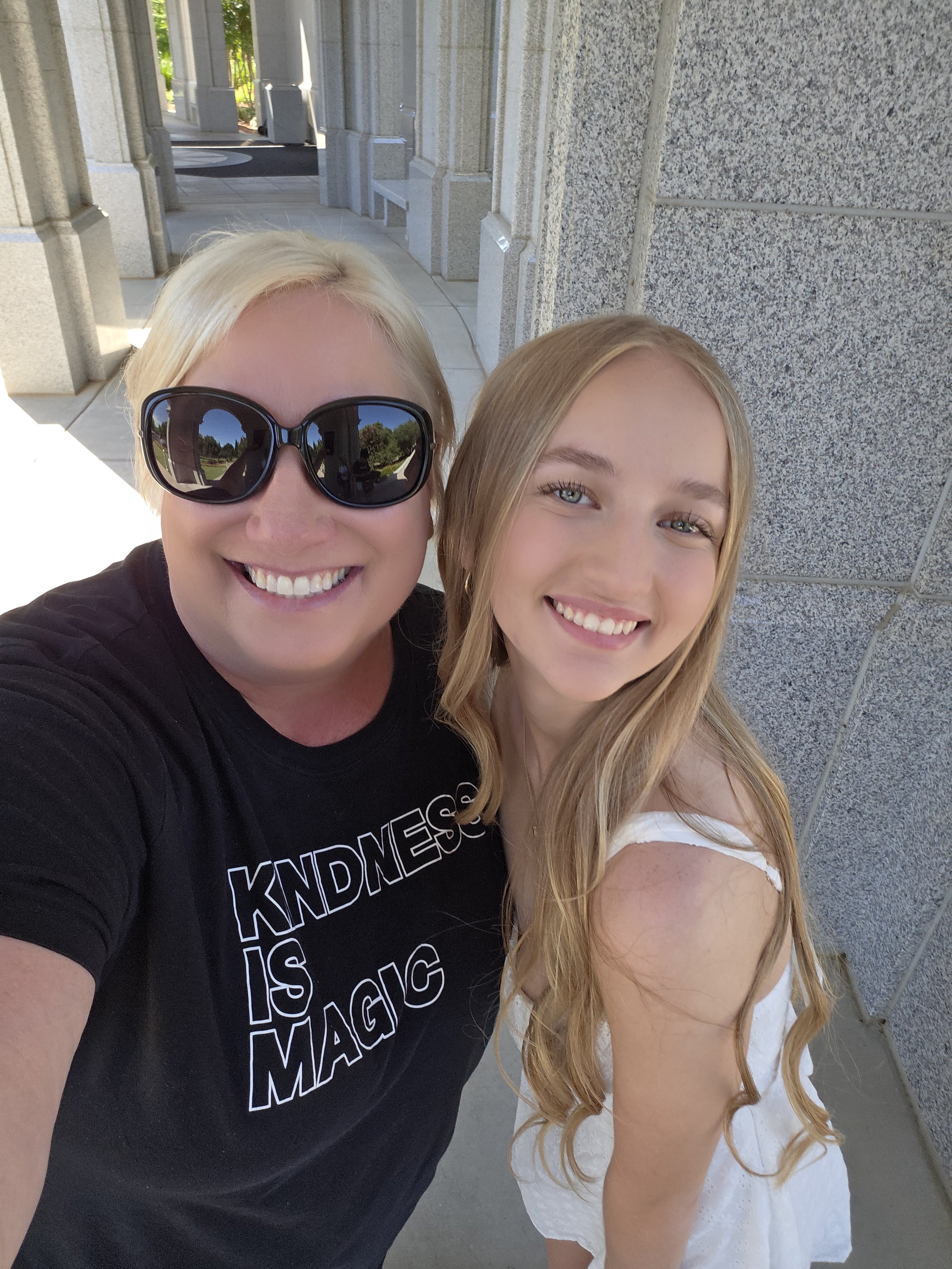 Photographer Michelle takes a selfie with a graduating senior during her cap n gown pictures