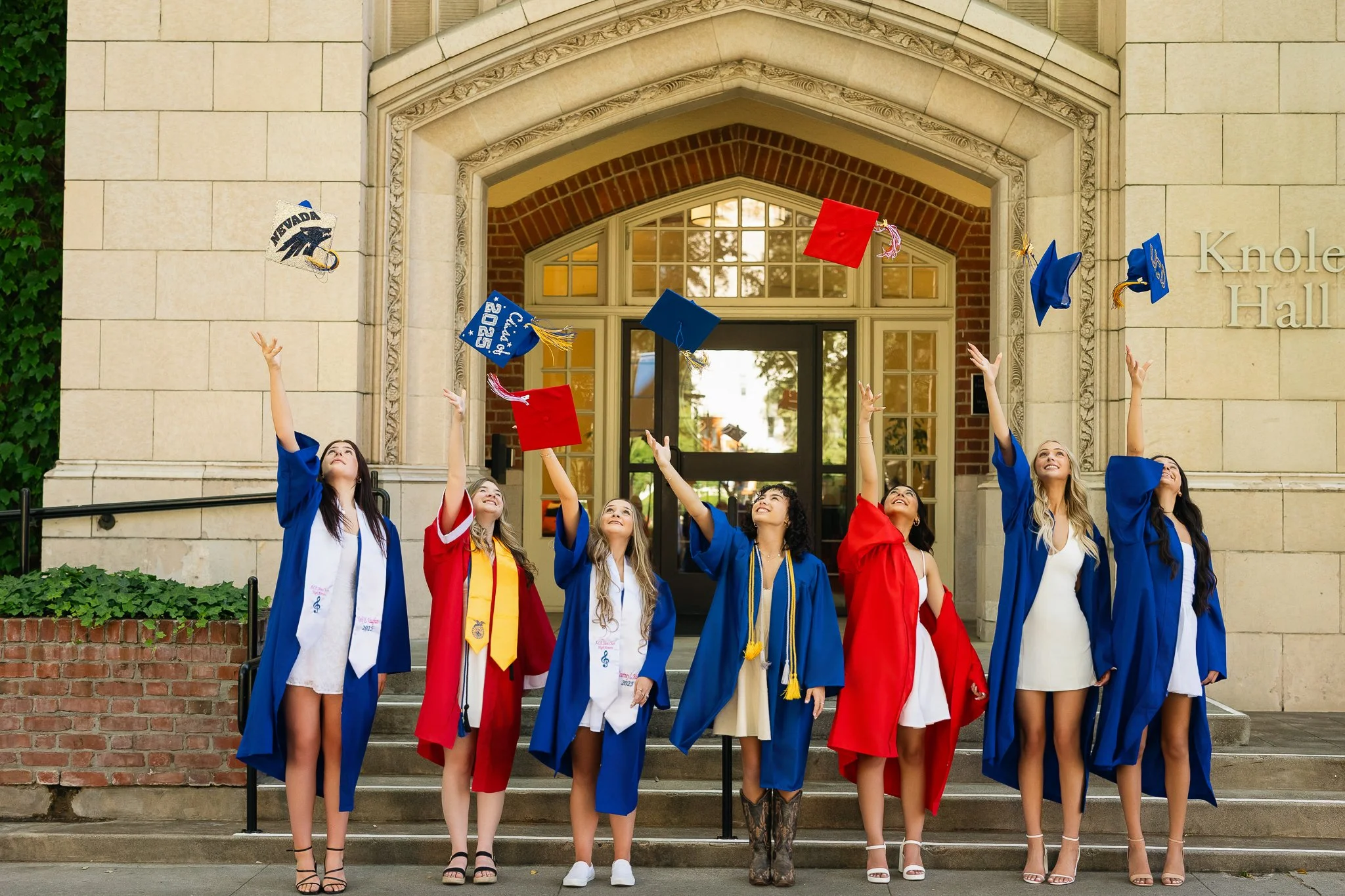 MC Senior VIP Team graduating seniors tossing their caps in the air during a fun cap and gown group photoshoot celebrating graduation.